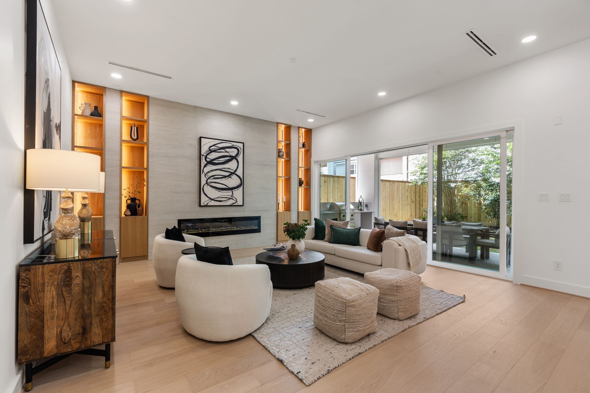 Modern kitchen with a central island, wood cabinets, and two gold pendant lights.