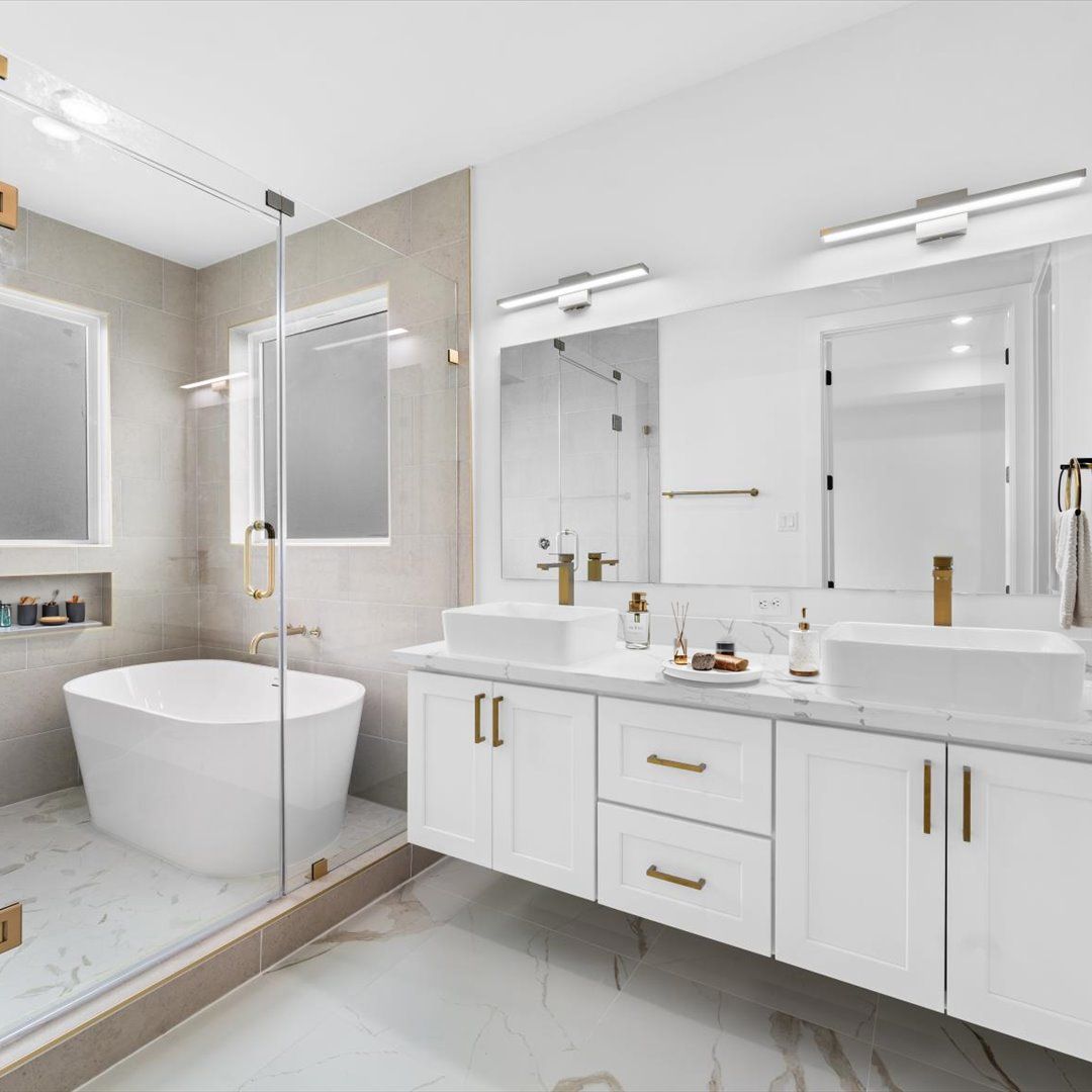 Modern bathroom with a soaking tub, double vanity, and glass shower. White and gold accents.