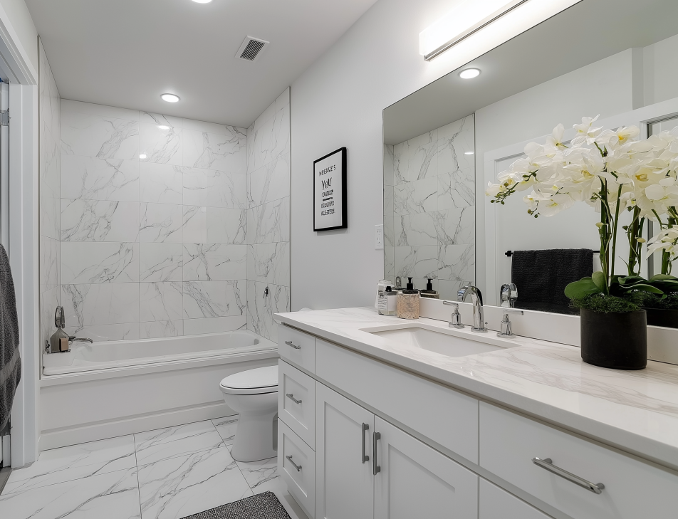 White marble bathroom with a white vanity, tub, and decorative flowers.