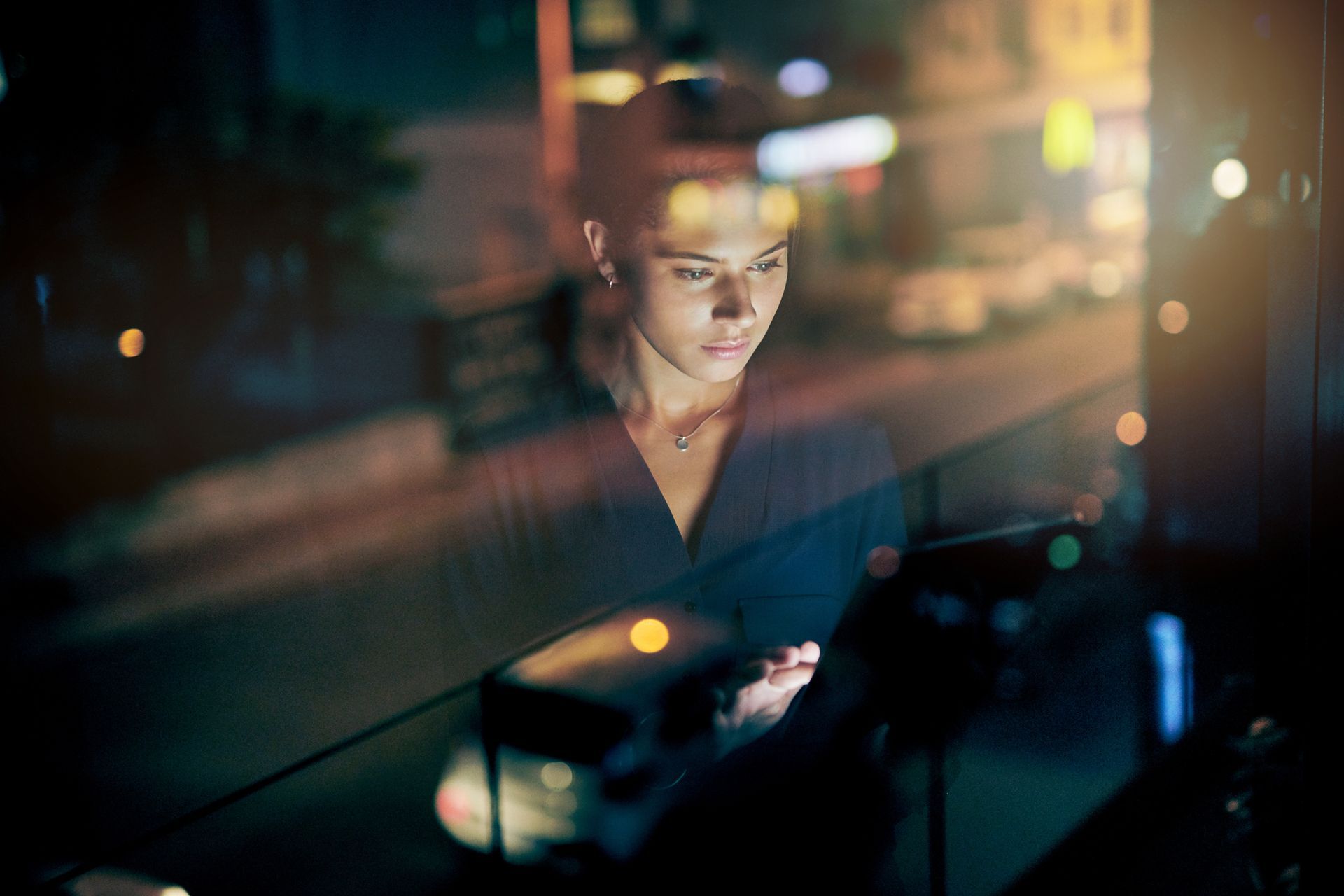 a woman looking out a window at night