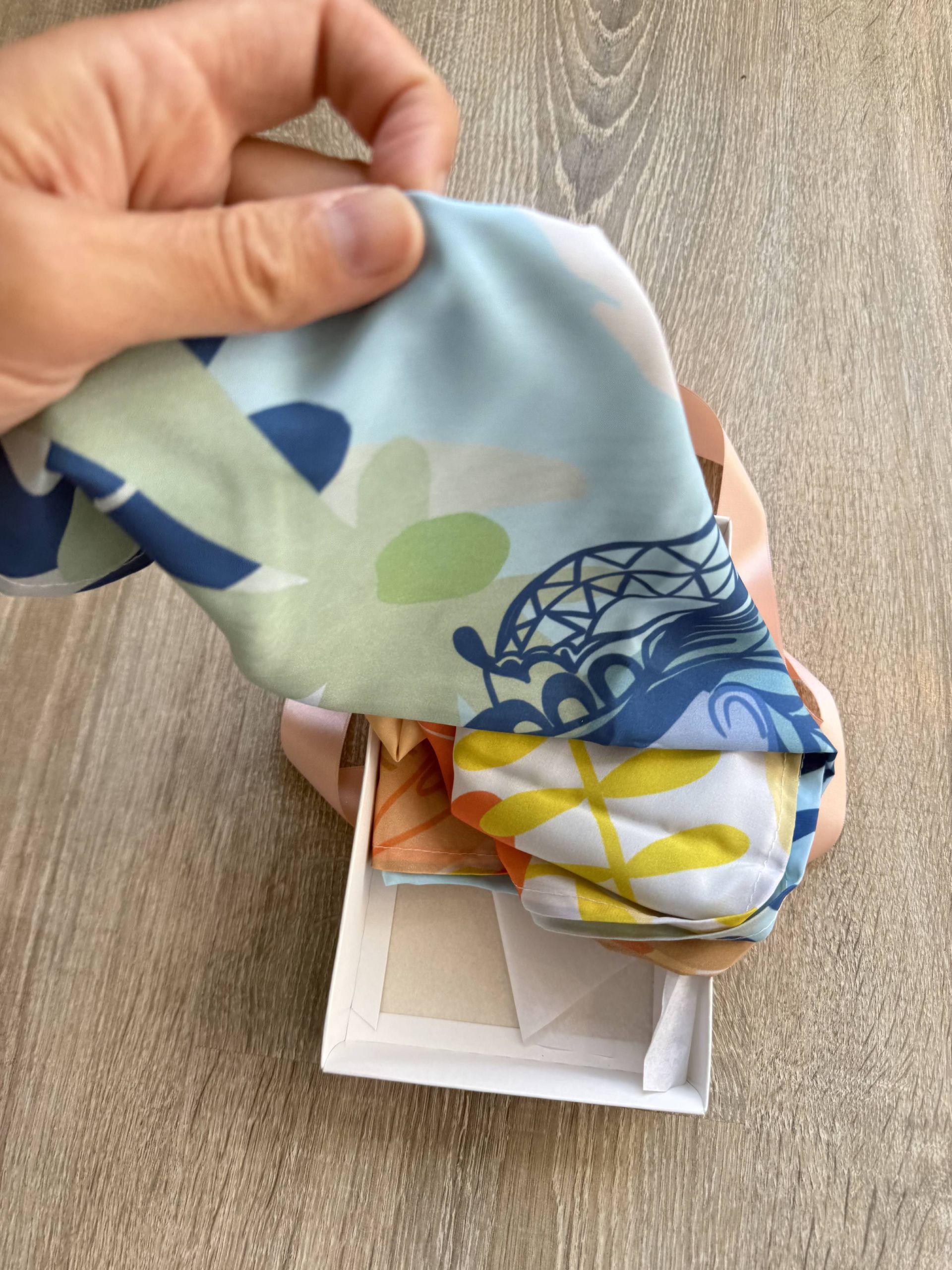 Bufanda infinita con estampado floral en tonos naranja, amarillo y azul.