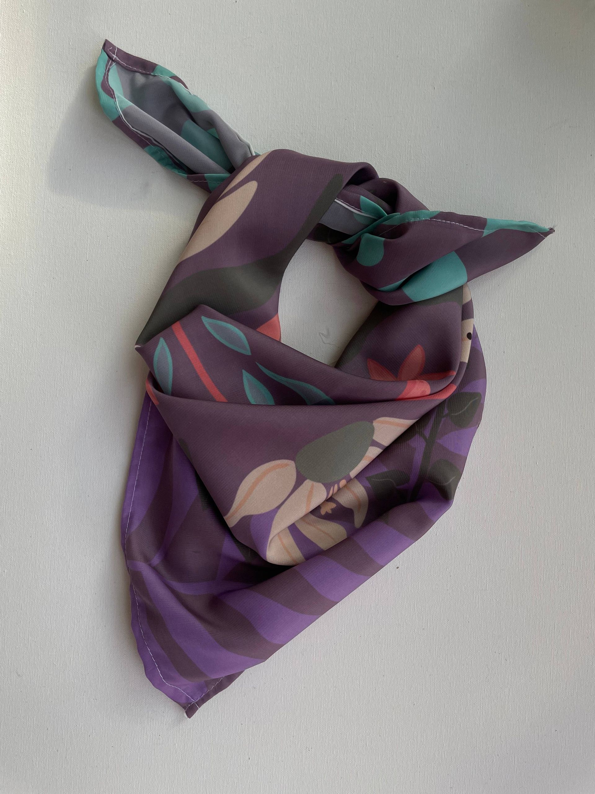 Una bufanda morada con flores y hojas.