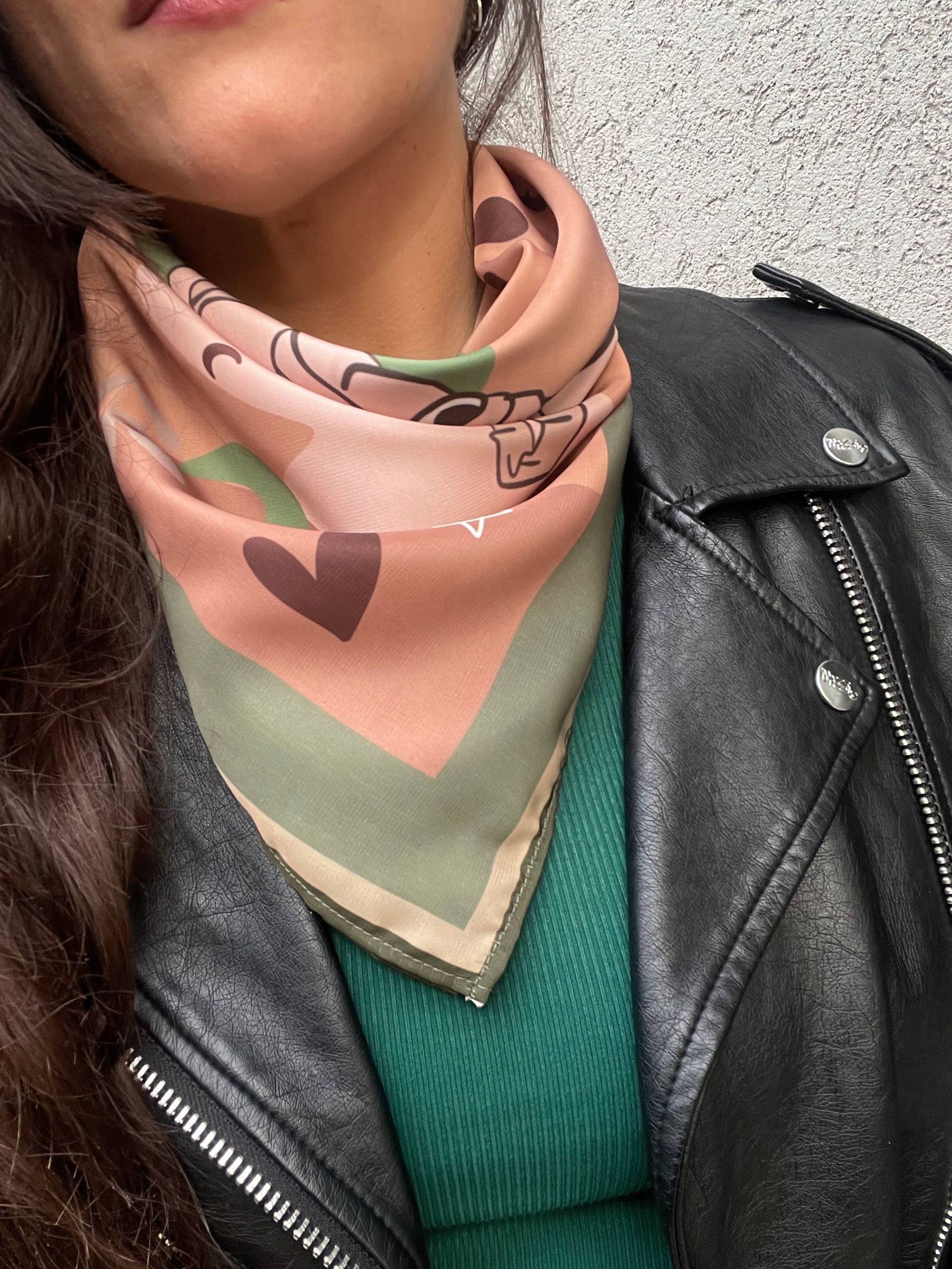 Una mujer que lleva una chaqueta de cuero y una bufanda alrededor del cuello.