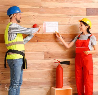 Un homme et une femme se tiennent côte à côte devant un mur en bois.