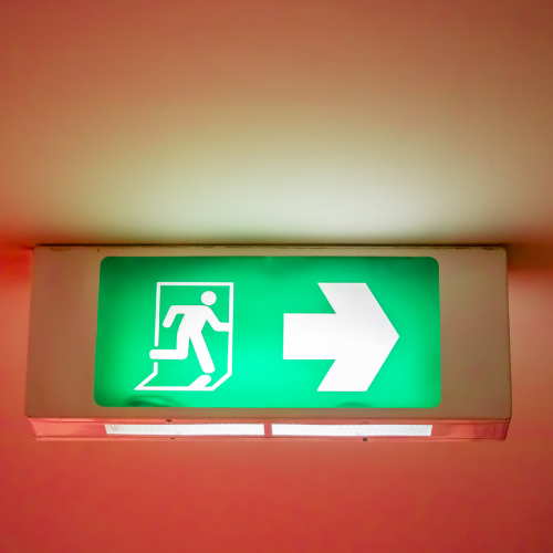 Un panneau de sortie vert avec une flèche pointant vers la droite