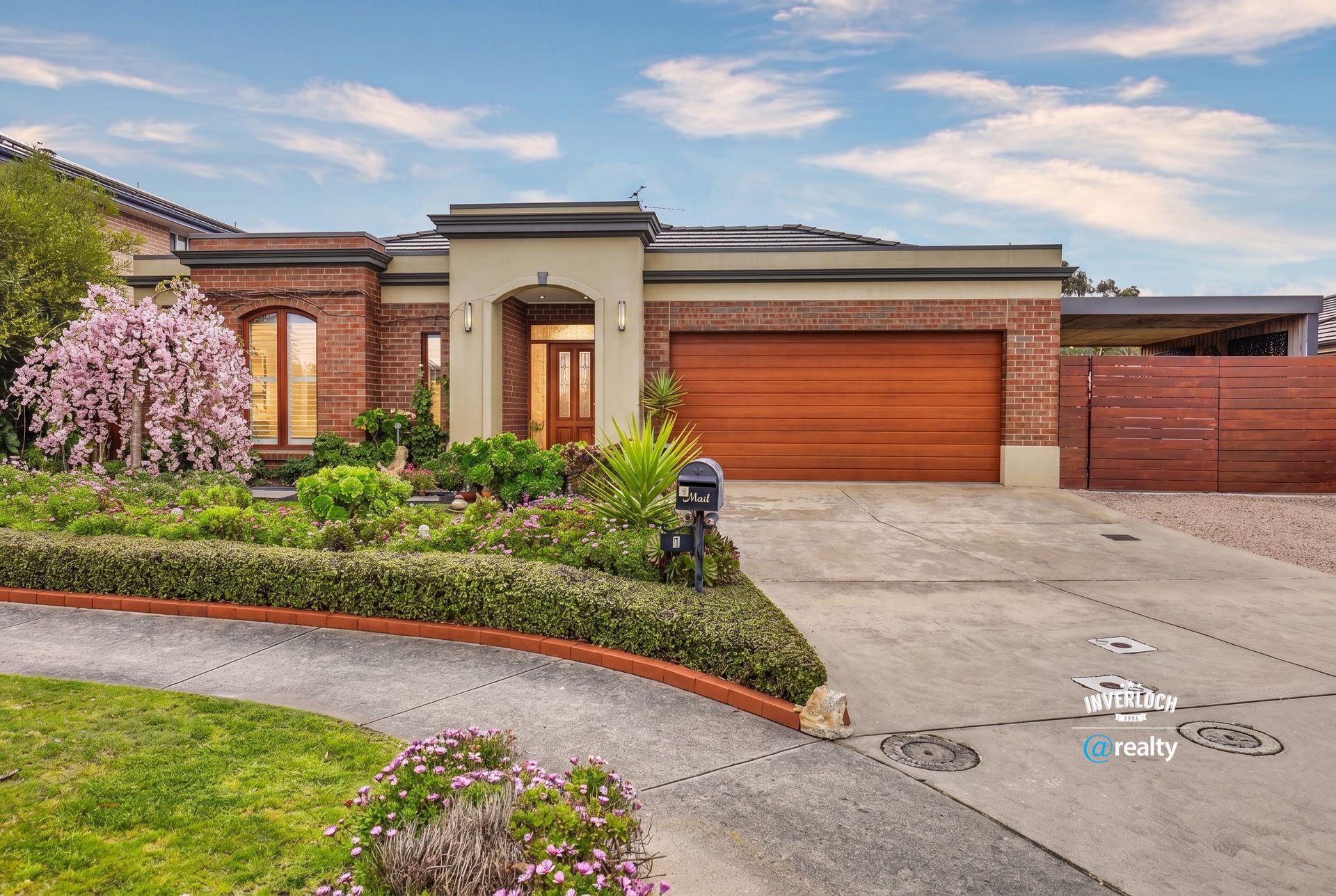 Modern single-story house with brick exterior, wood garage door, and landscaped front yard