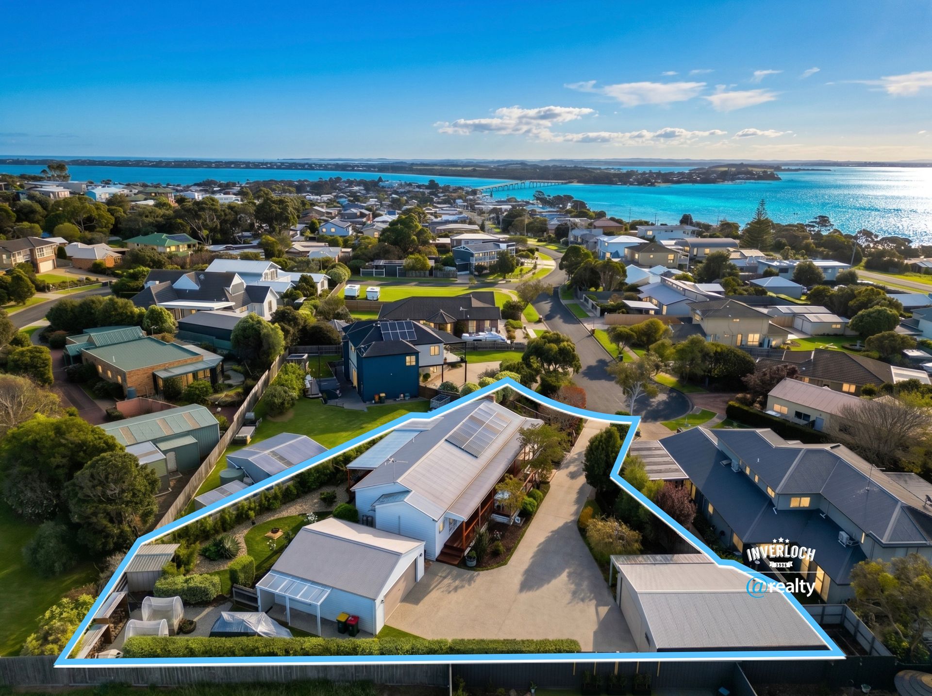 Aerial view of a coastal neighborhood with a highlighted property lot near the water