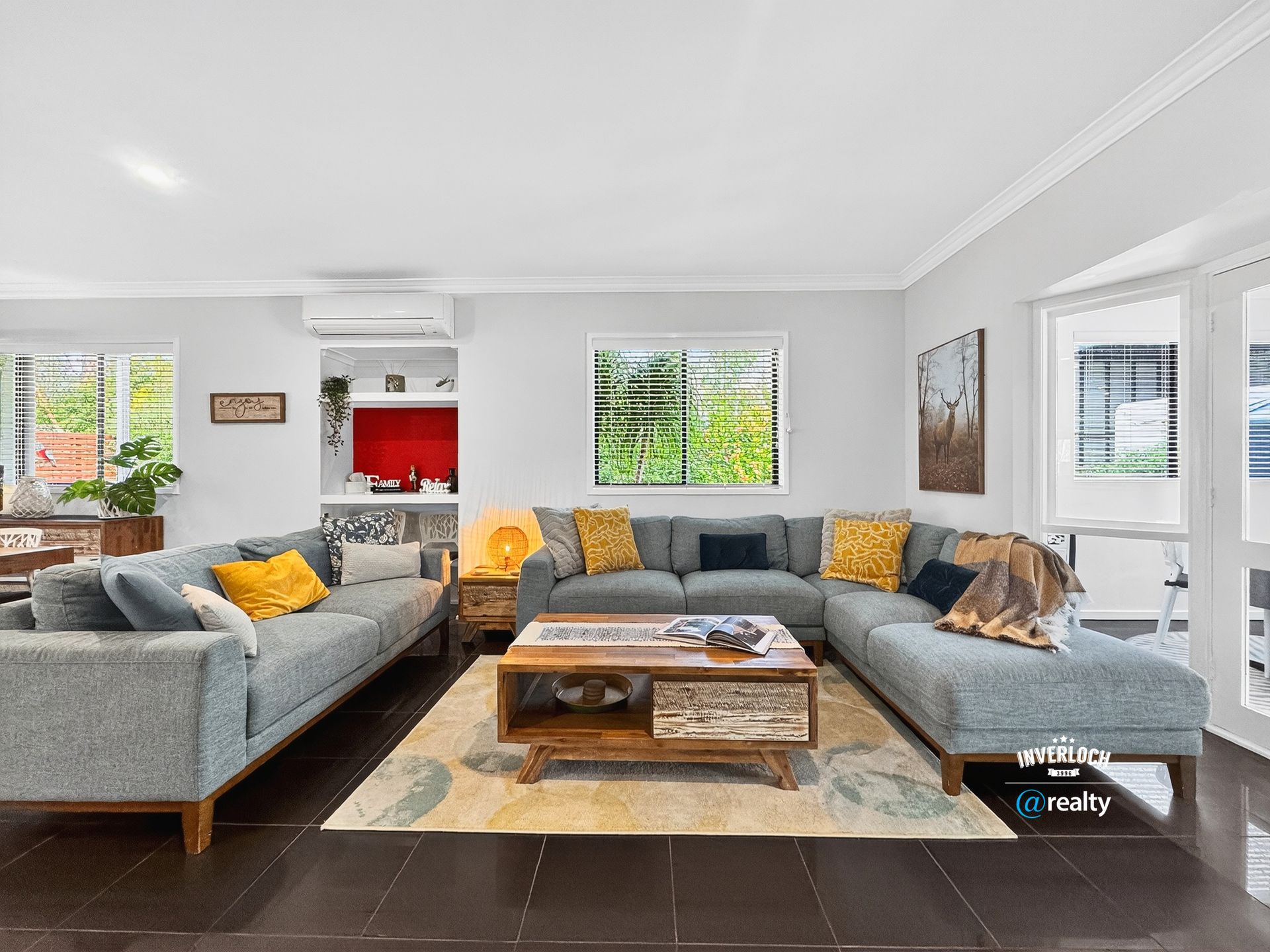 Living room with blue sectional sofa, coffee table, rug, and large windows.