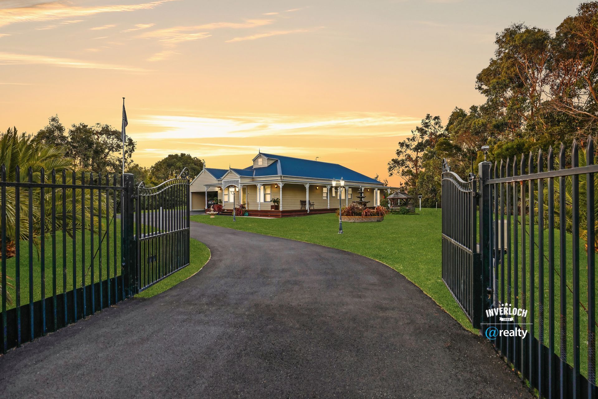 A large white house with blue garage doors is for sale