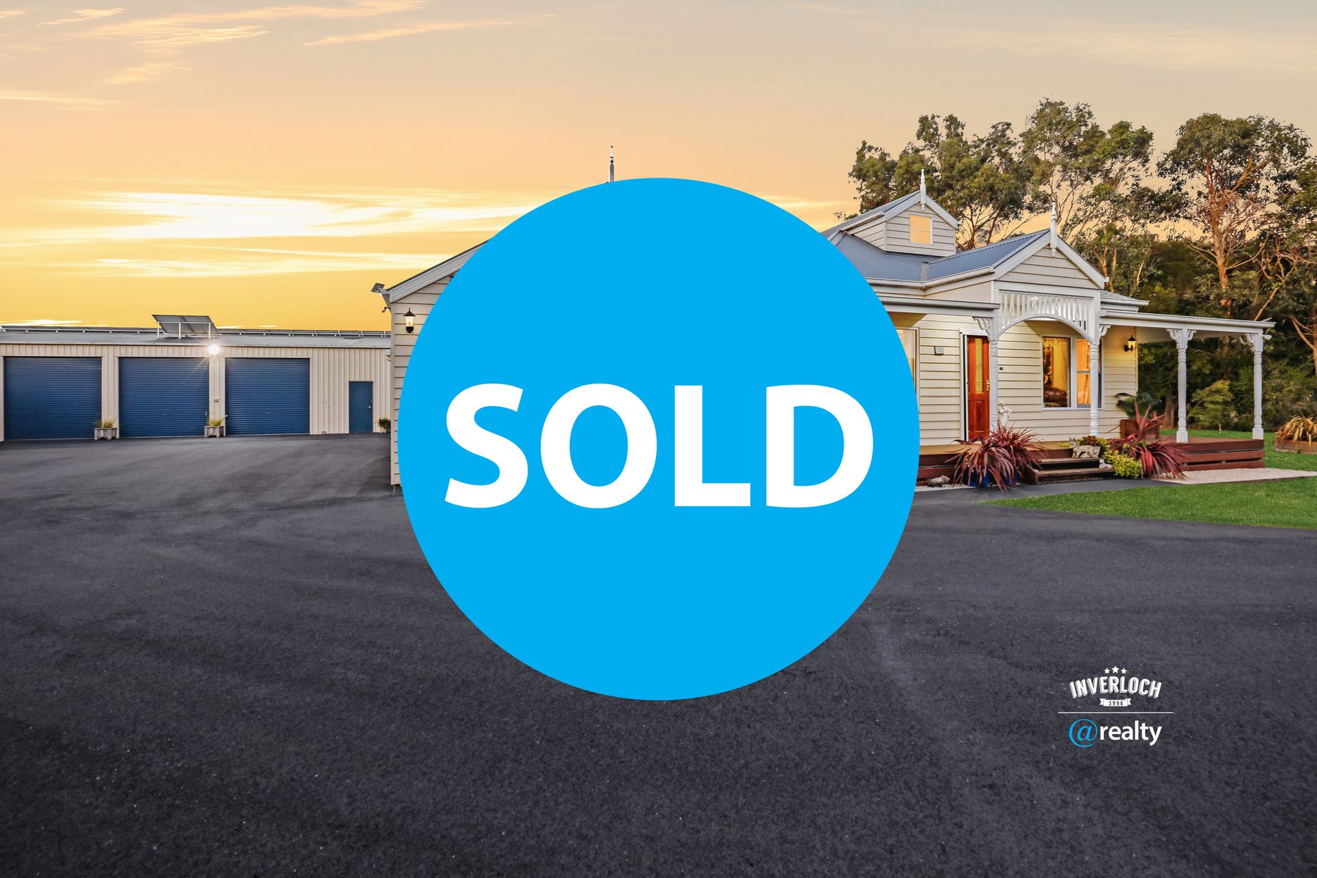 A large white house with blue garage doors is for sale