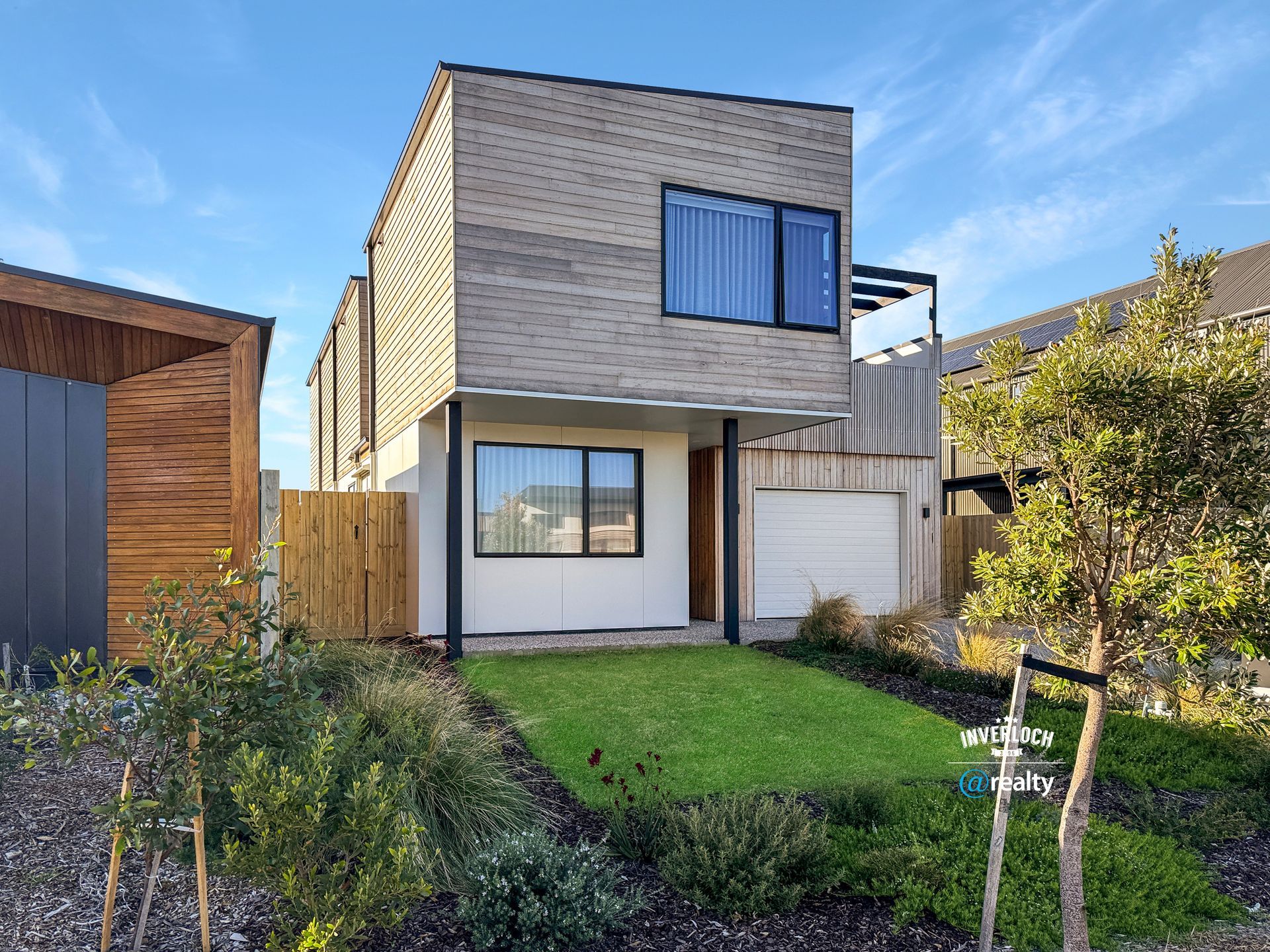 A modern house with a large lawn in front of it.