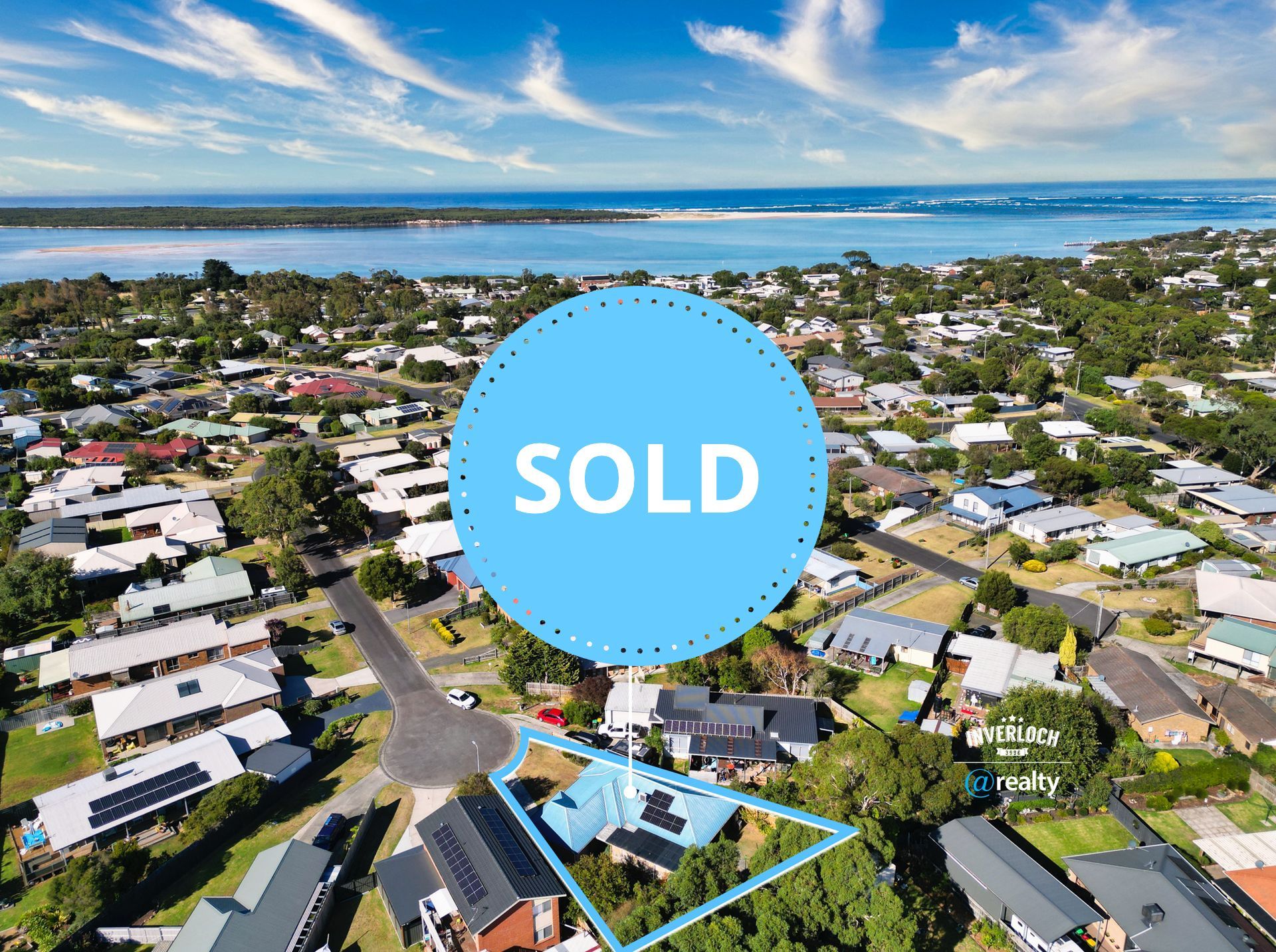 An aerial view of a residential area with a large body of water in the background.