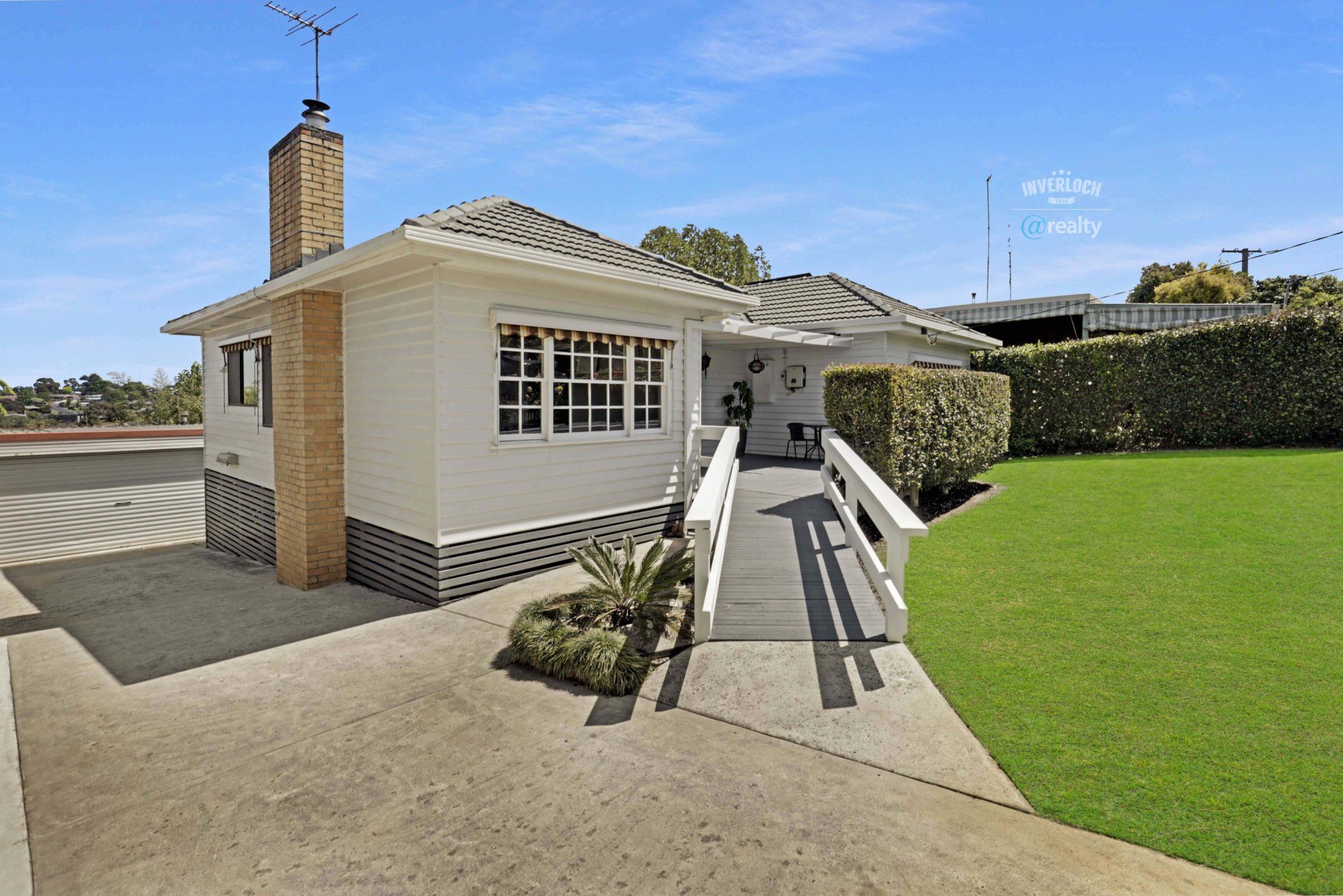 A small white house with a ramp leading to the front door.