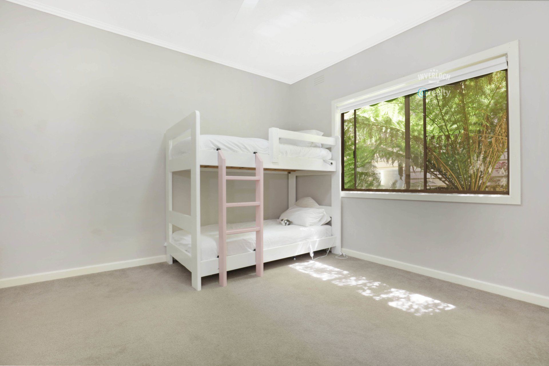 An empty bedroom with a bunk bed and a window.