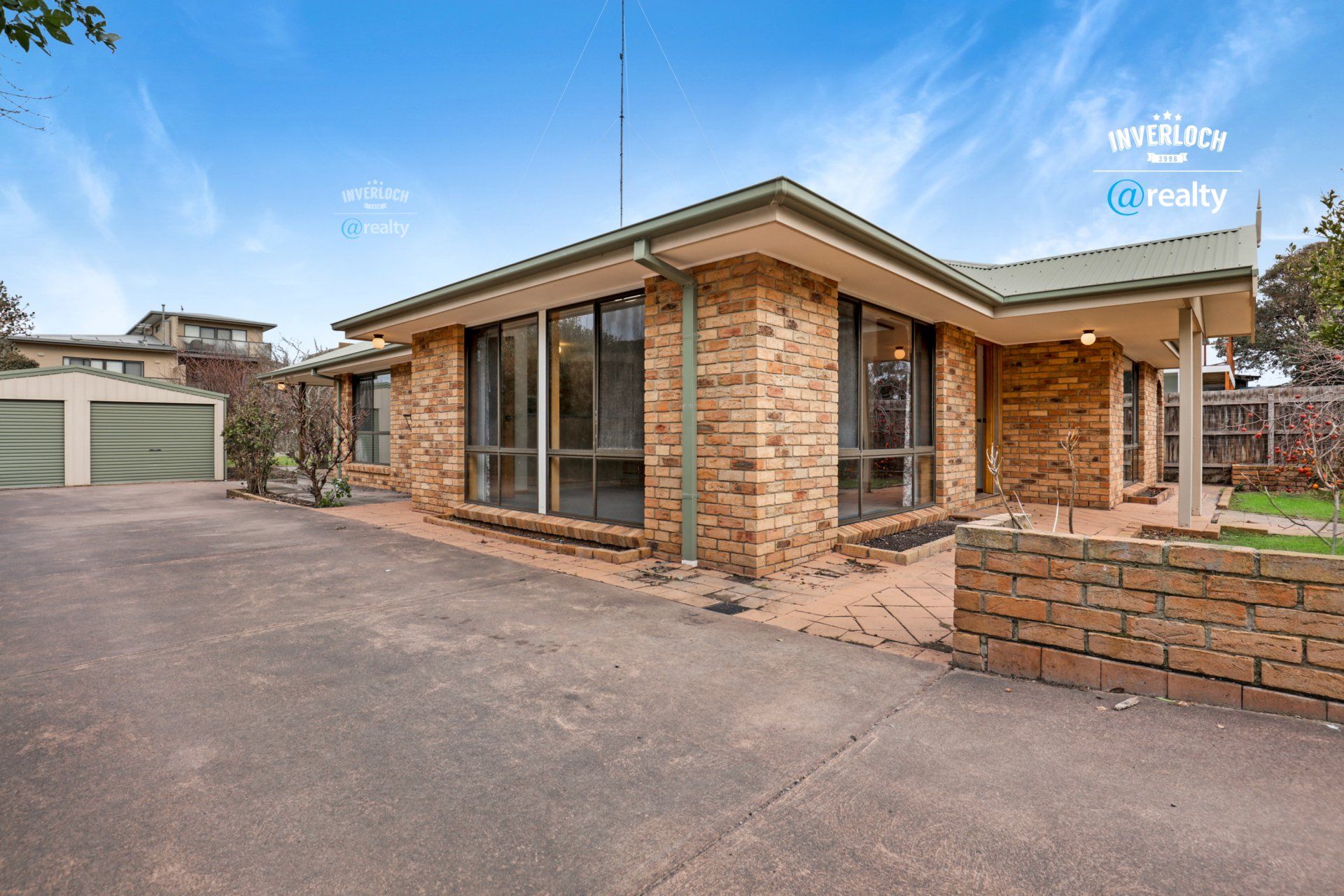 A brick house with a garage and a lot of windows