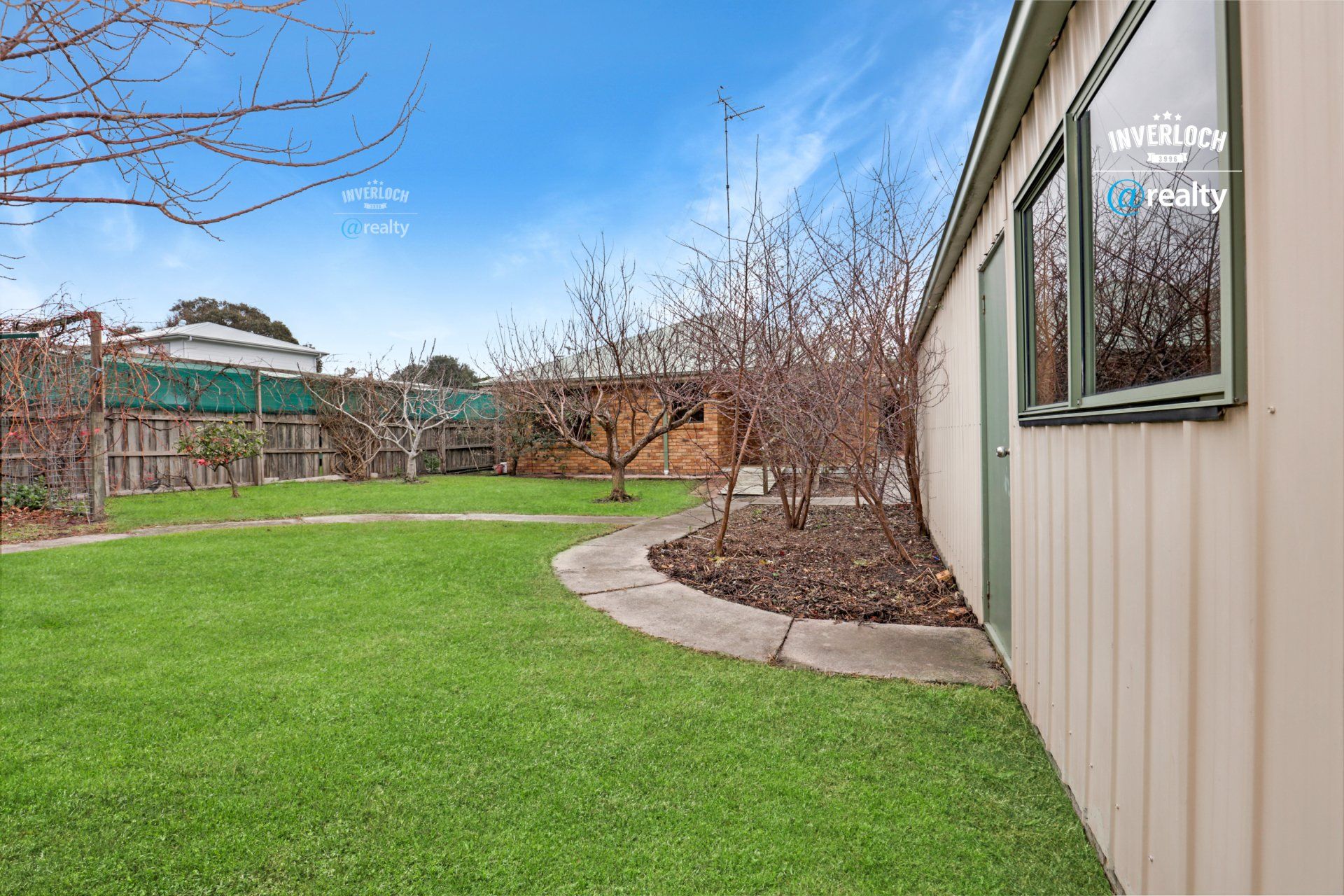 A house with a large lawn and a shed in the backyard.