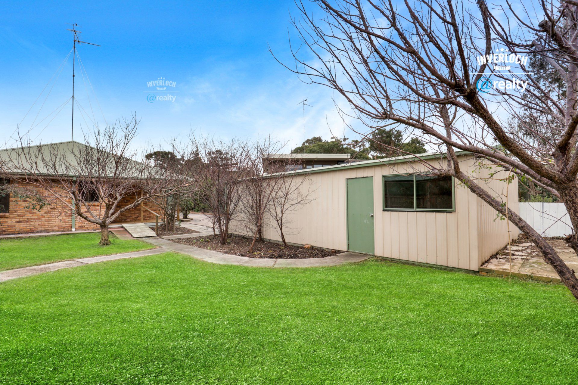 There is a shed in the backyard of a house.