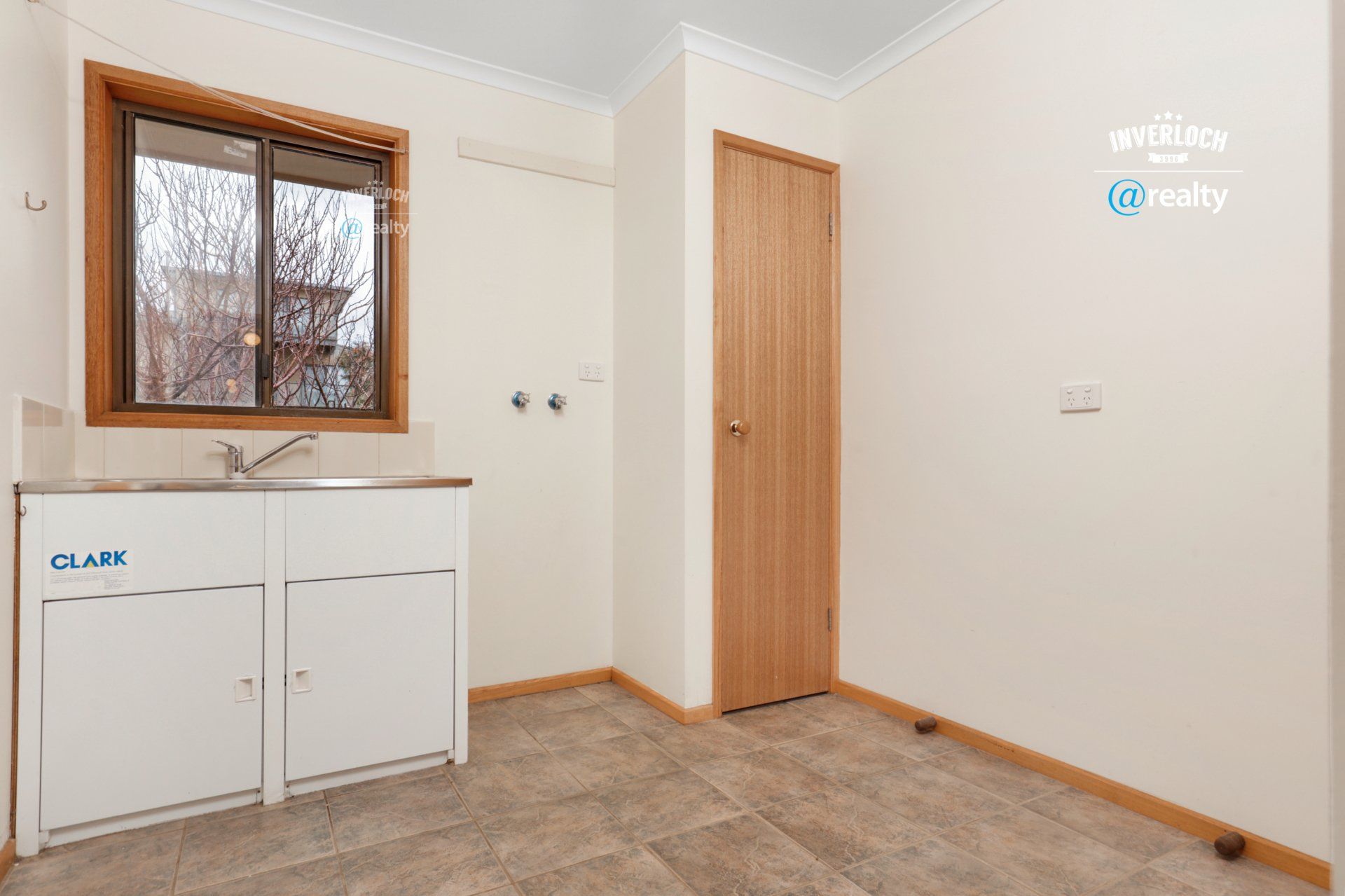 An empty room with a sink and a window