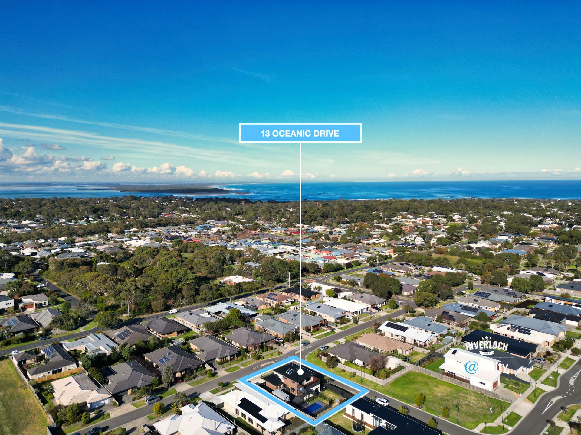 An aerial view of a residential area with the ocean in the background