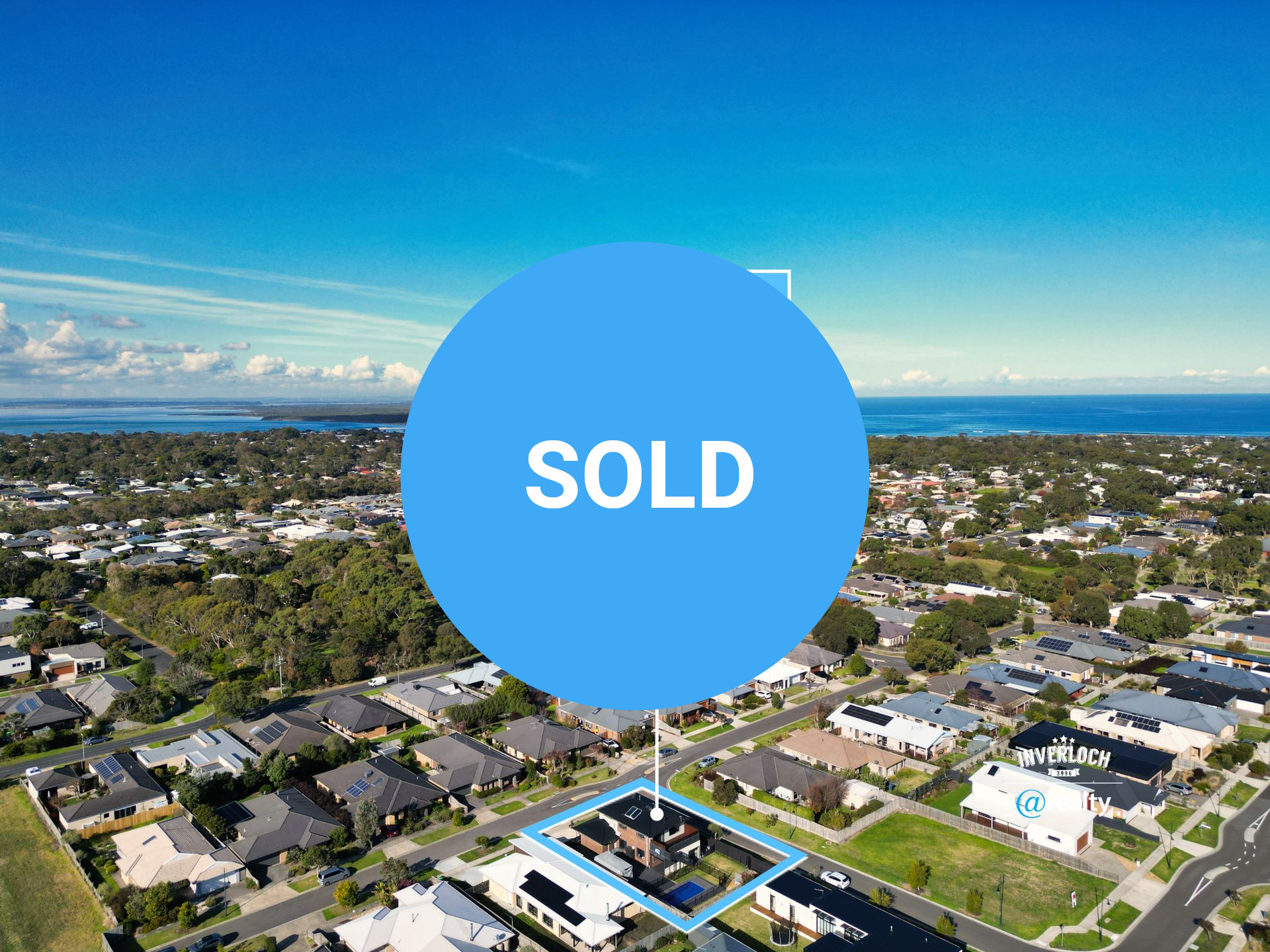 An aerial view of a residential area with the ocean in the background
