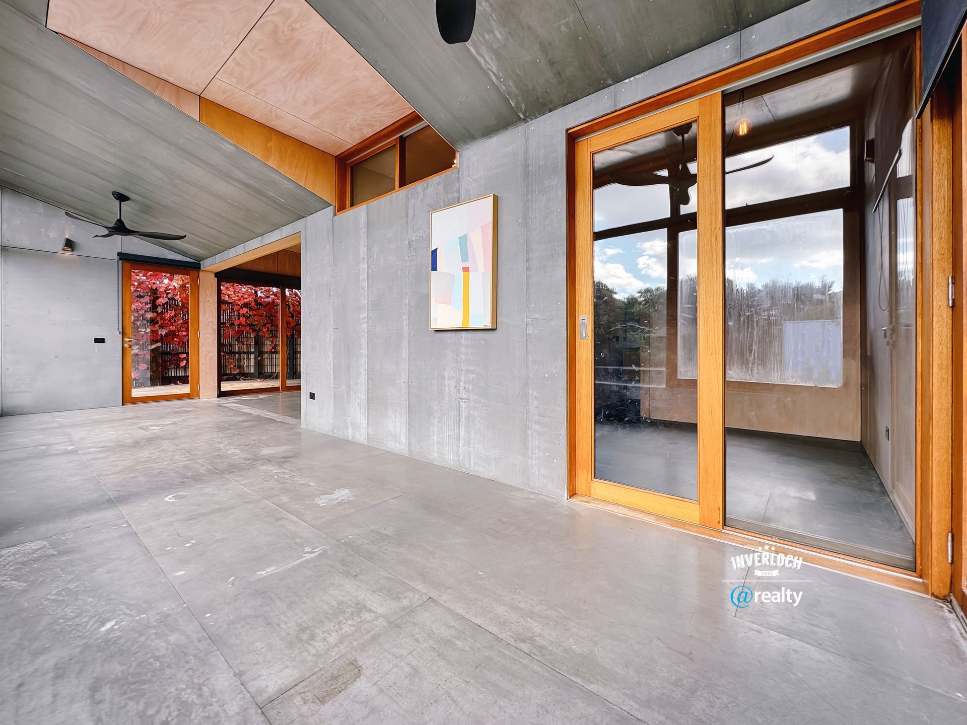 A large room with a lot of windows and a painting on the wall