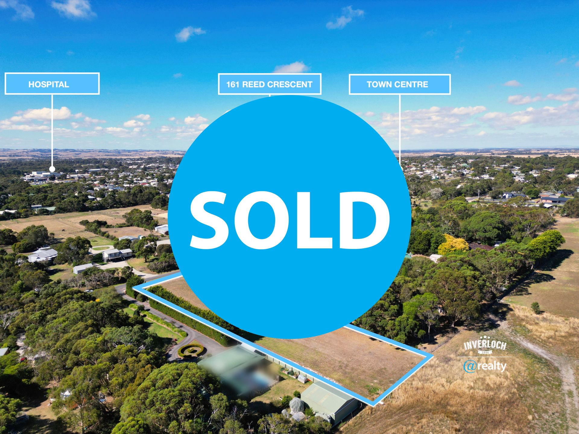 An aerial view of a residential area with a sold sign in the middle.
