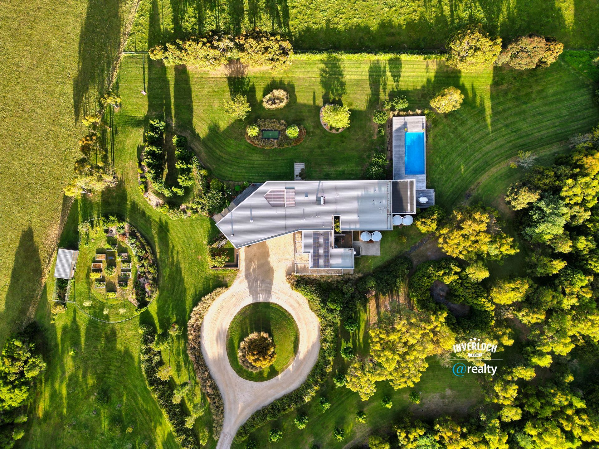 Two white chairs are sitting on top of a lush green lawn with a view of a valley.