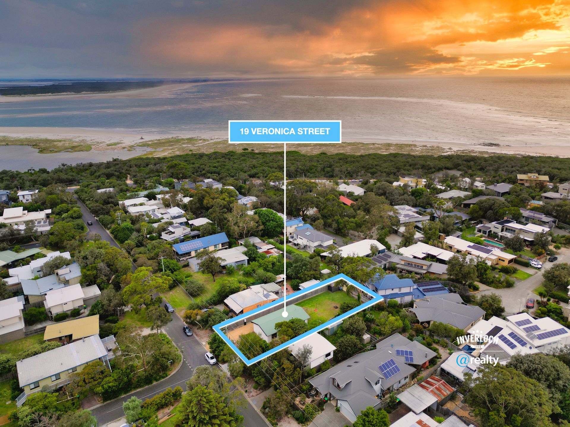 An aerial view of a residential area with a large body of water in the background.