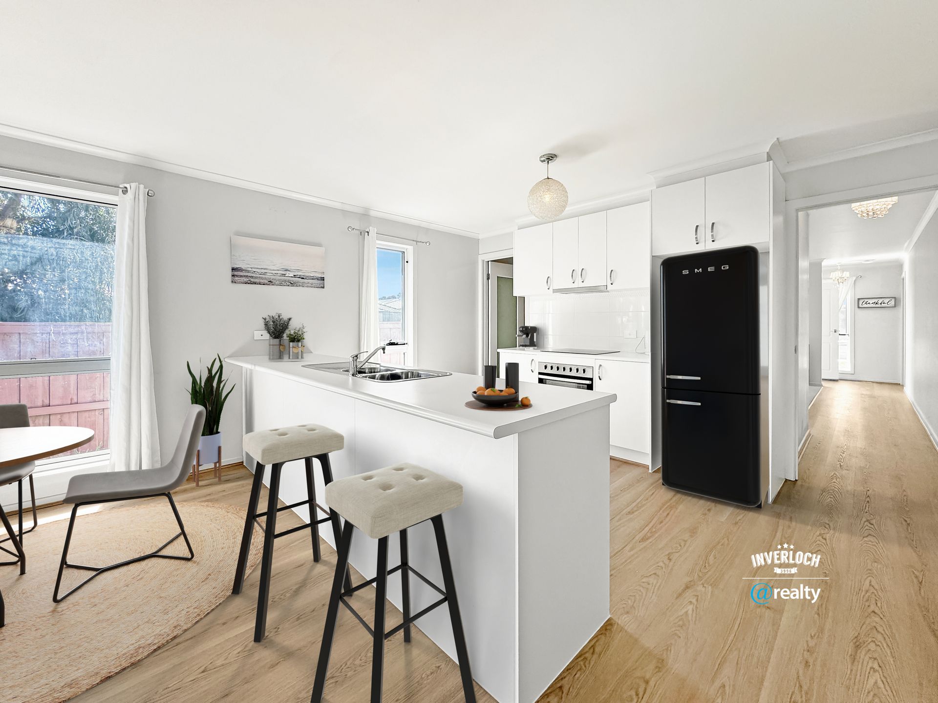 A kitchen with white cabinets and a black refrigerator.