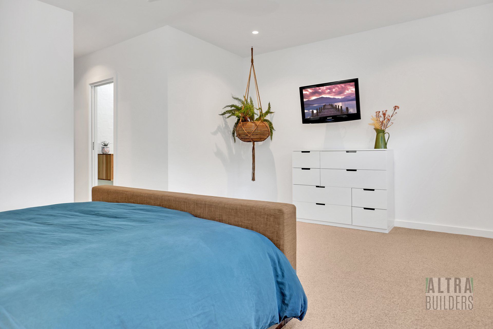 A bedroom with a bed and a television on the wall