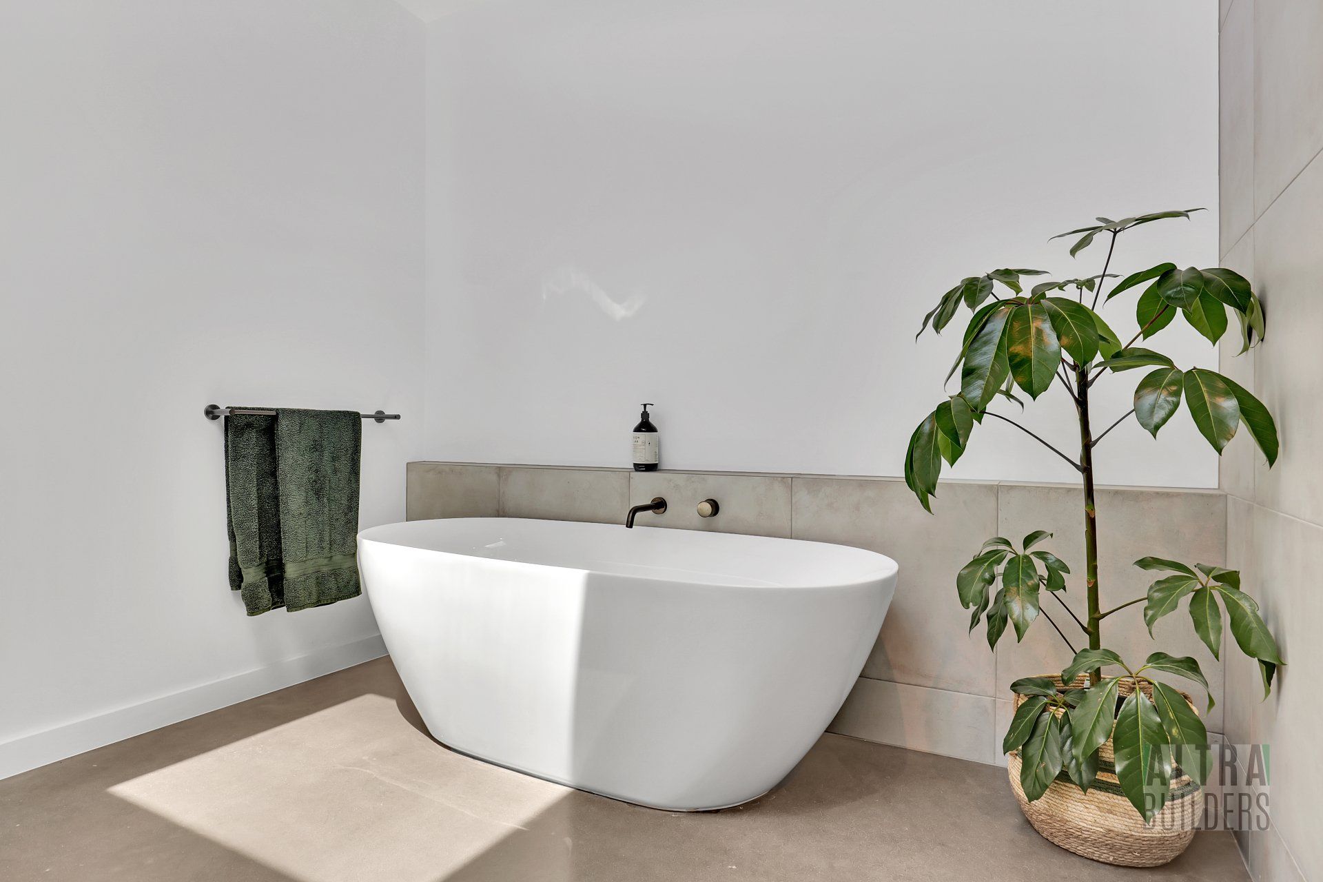 A bathroom with a bathtub and a potted plant.