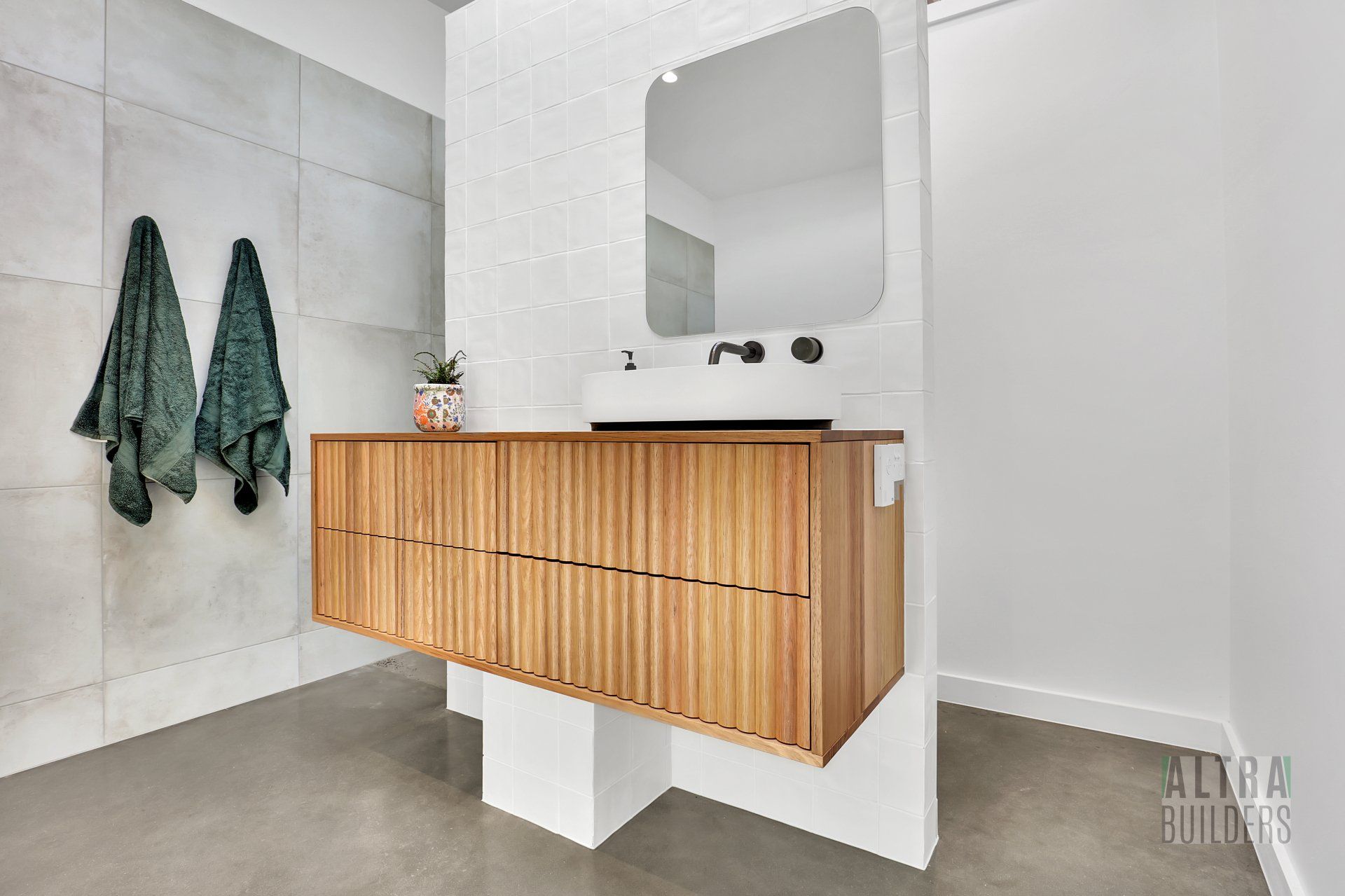 A bathroom with a wooden vanity , sink and mirror.
