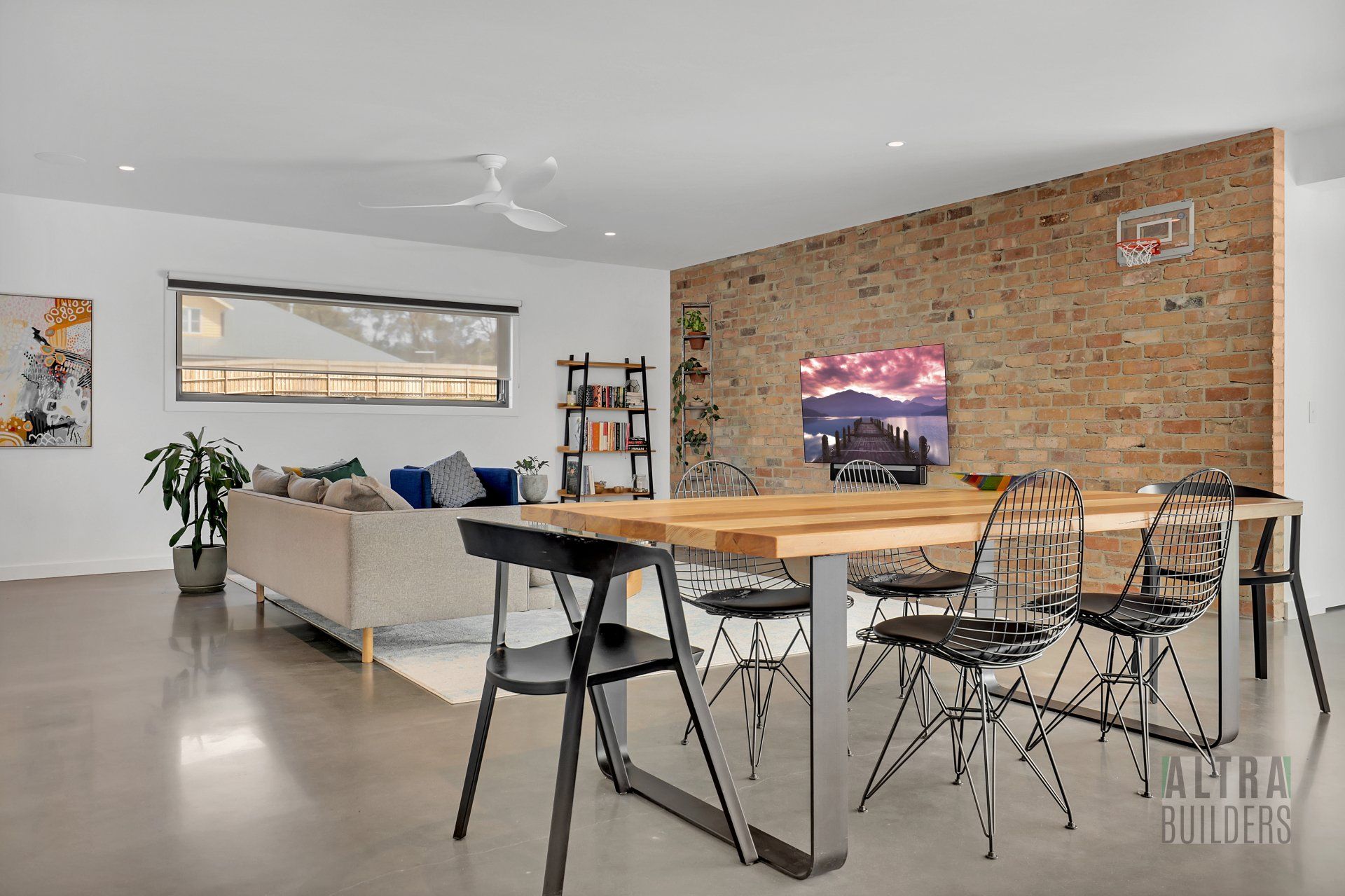 A living room with a table and chairs and a brick wall