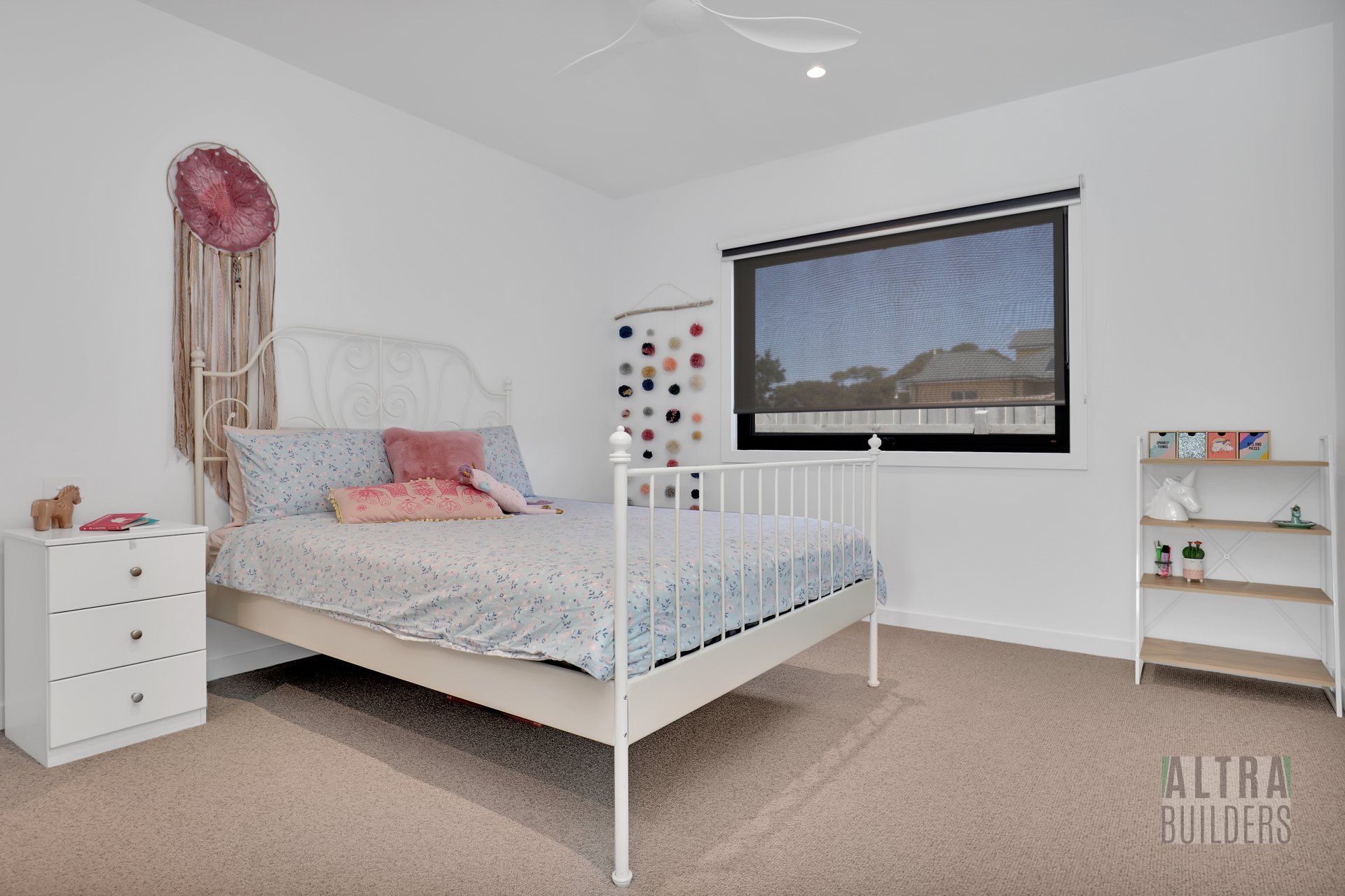 A bedroom with a bed , nightstand , dresser and window.