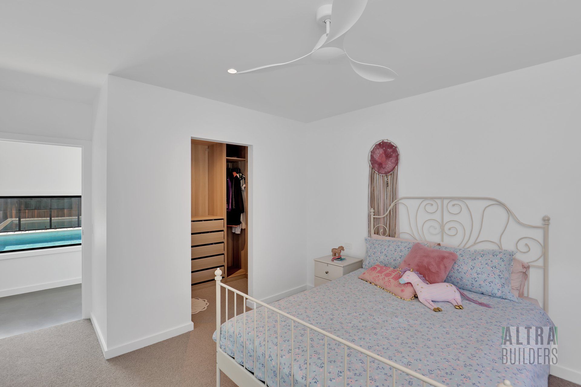 A bedroom with a large bed and a ceiling fan