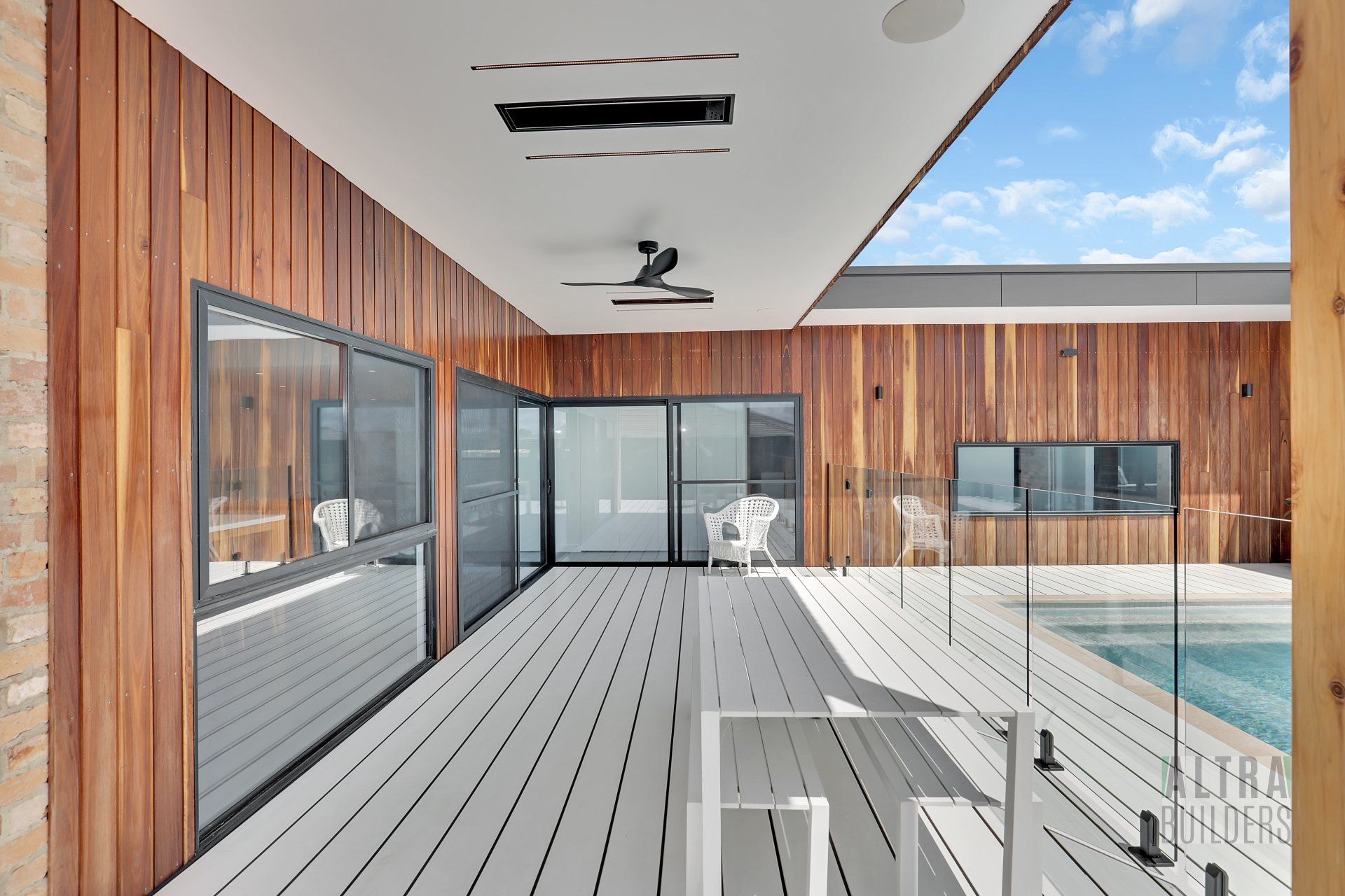 There is a large deck with a swimming pool in the background.