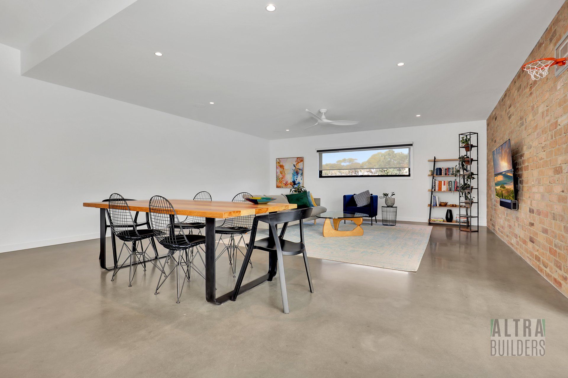 A living room with a table and chairs and a brick wall.