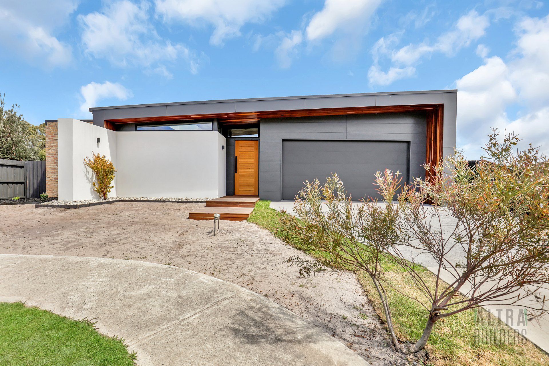 A modern house with a gray garage door and a wooden door