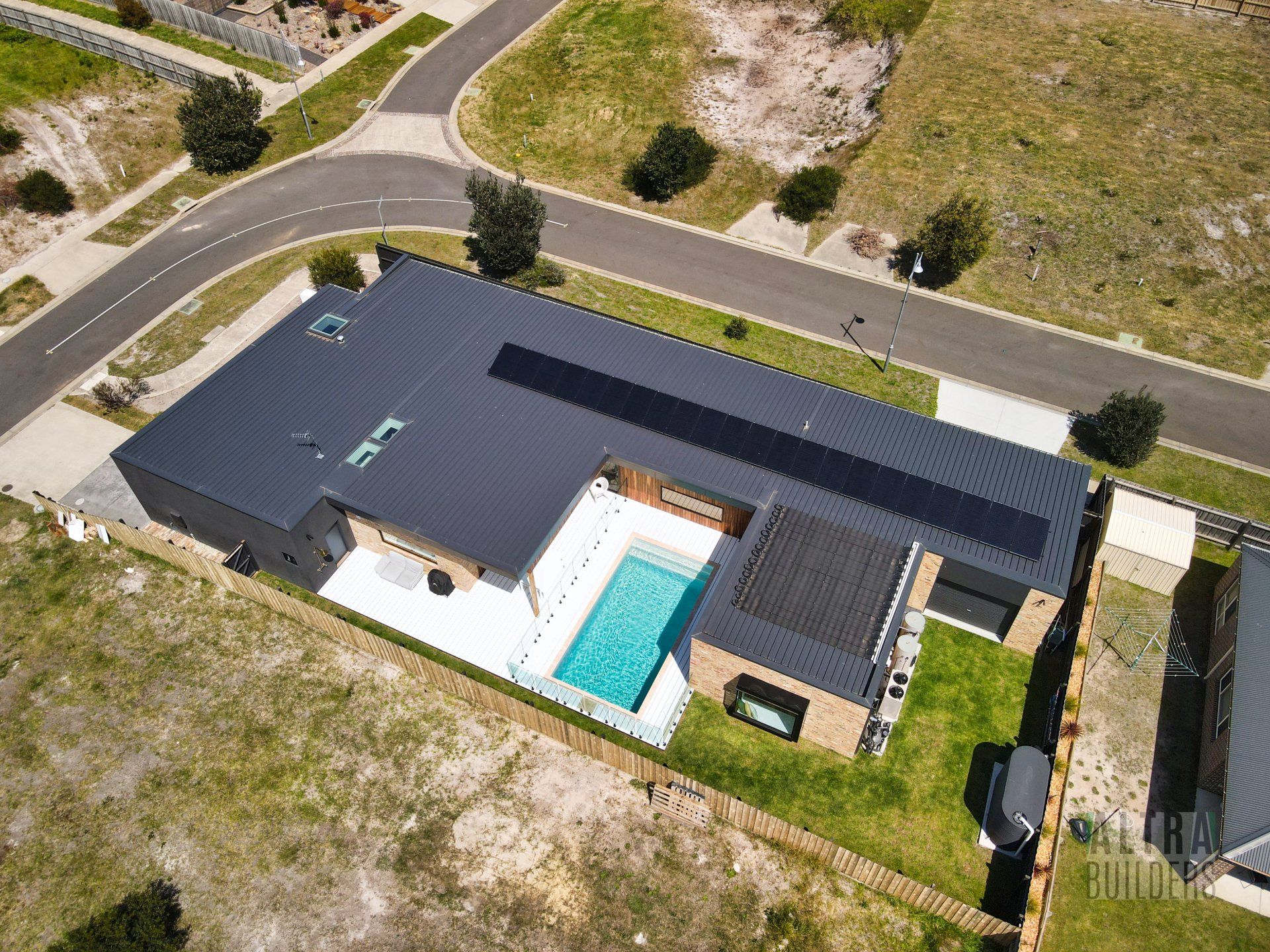 An aerial view of a house with a pool and solar panels on the roof.
