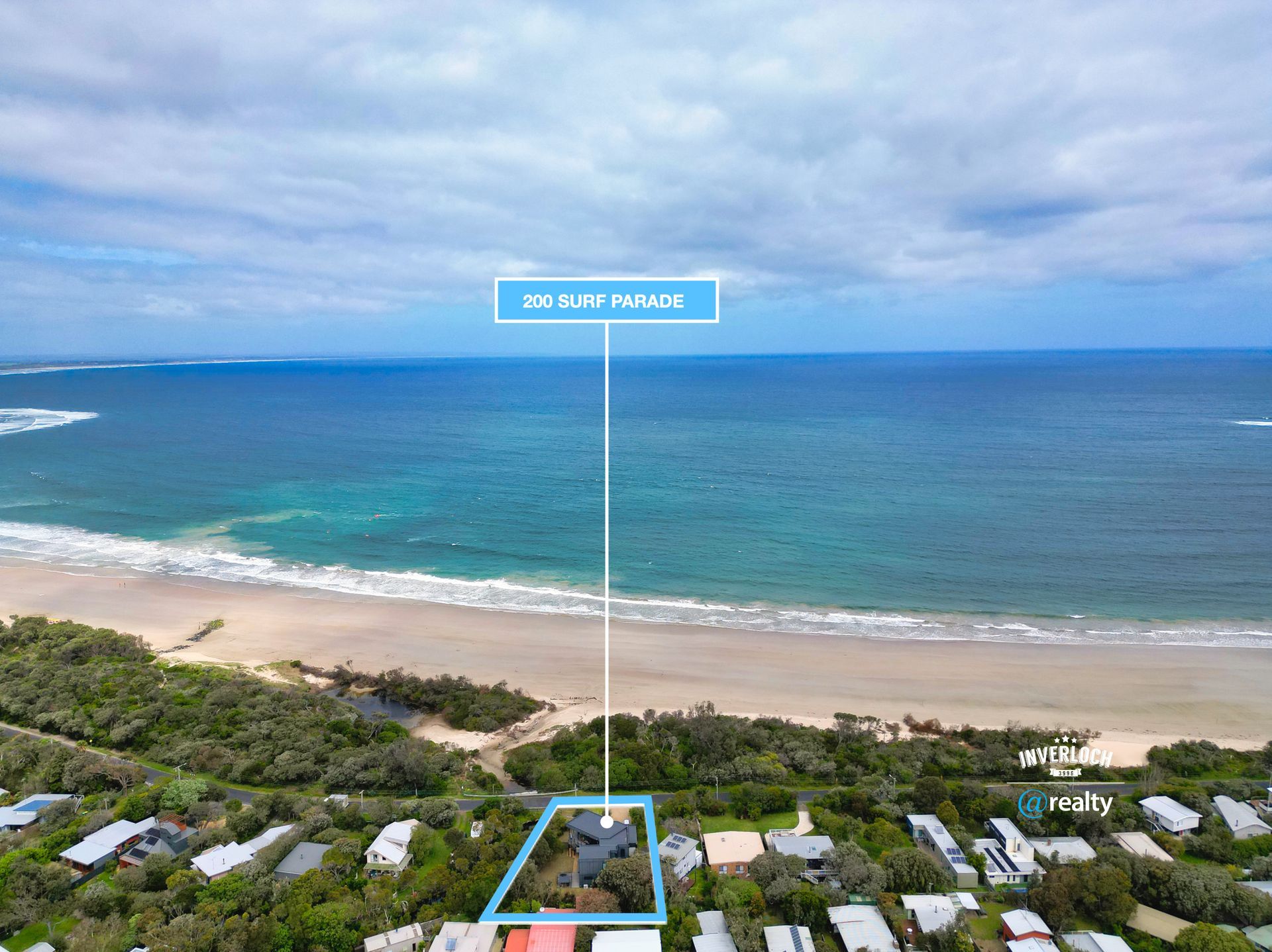 An aerial view of a house on a beach next to the ocean.