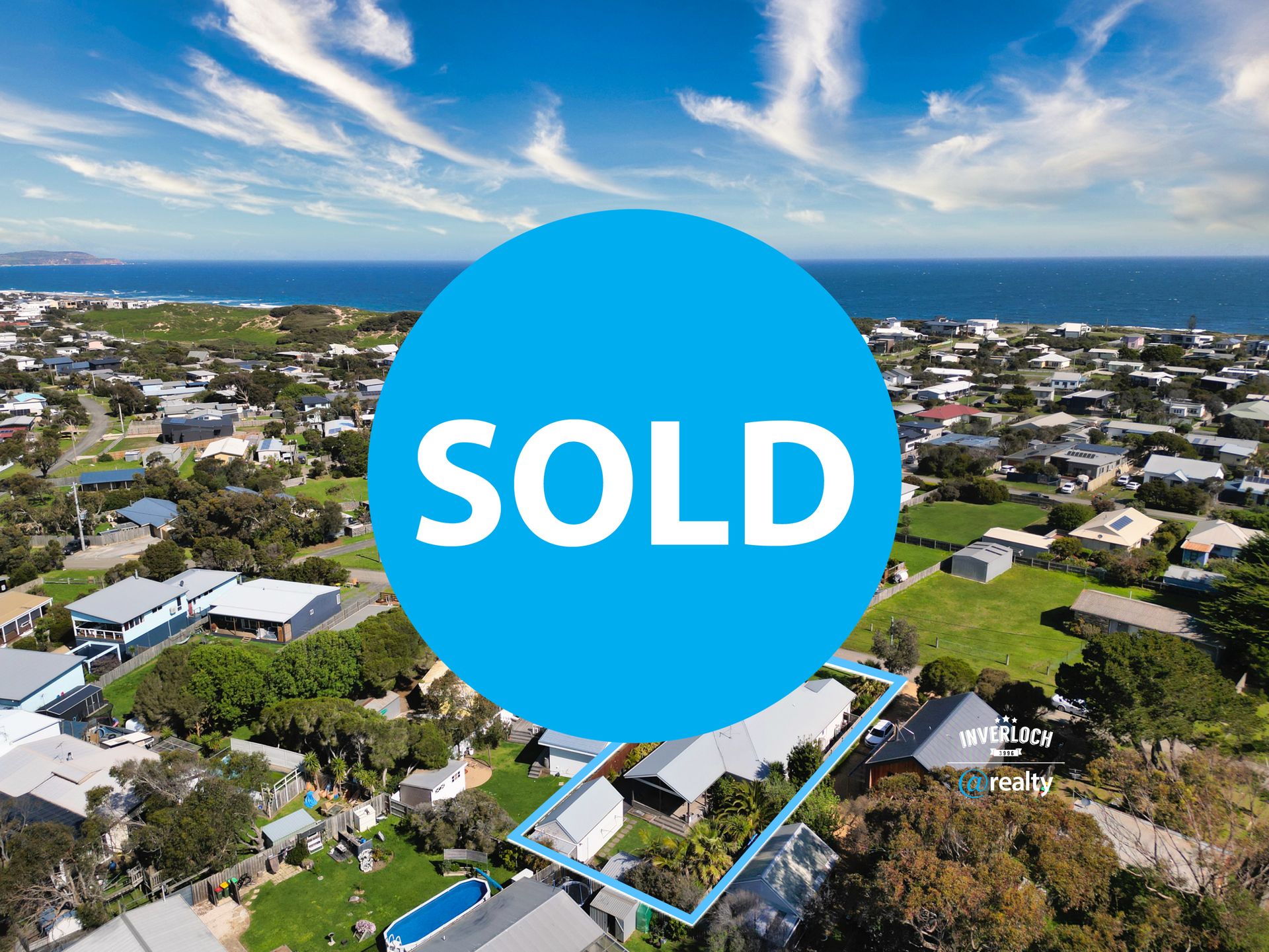 An aerial view of a residential area with a sold sign in the middle.