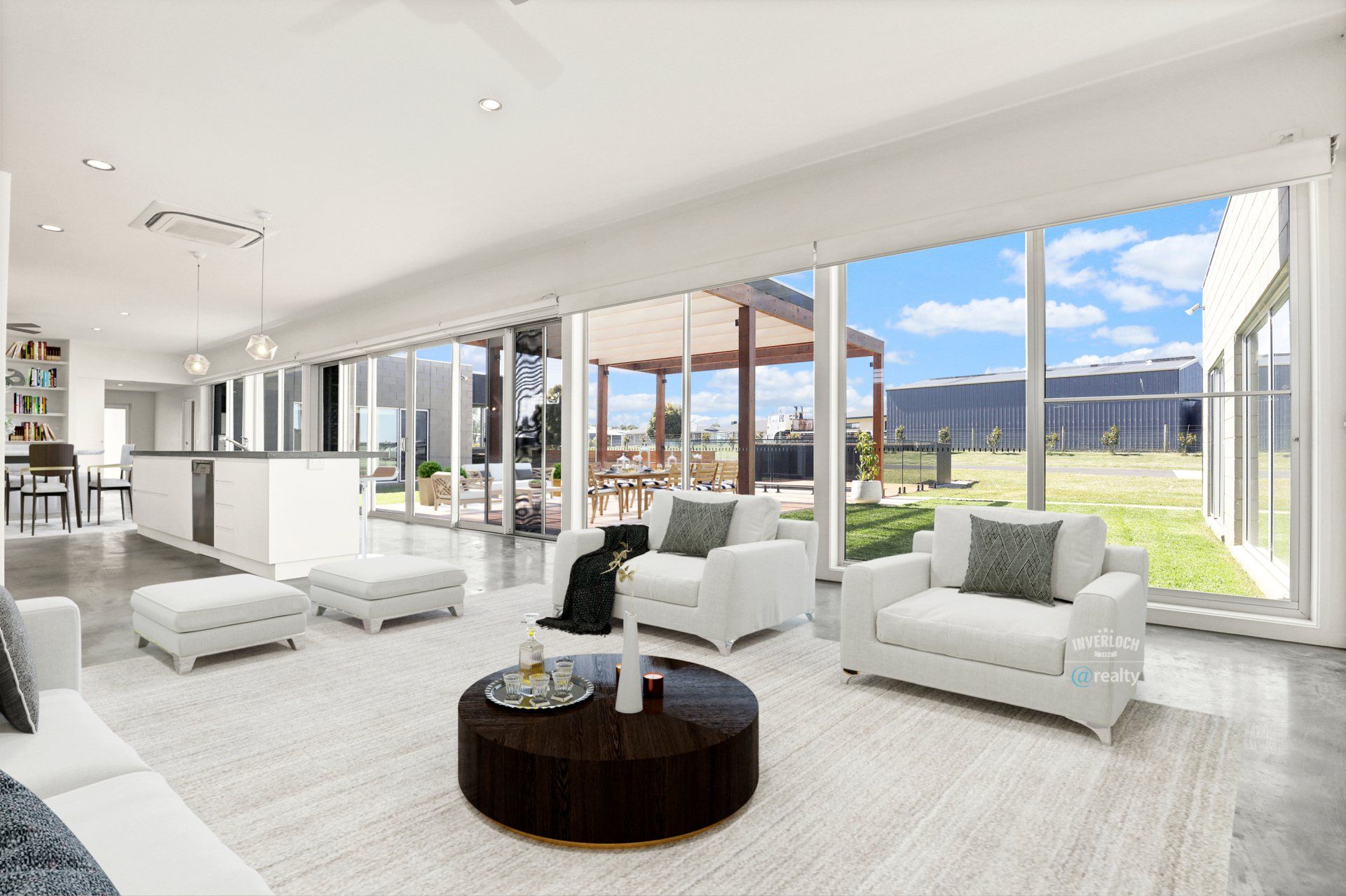 A living room with white furniture and a round coffee table.