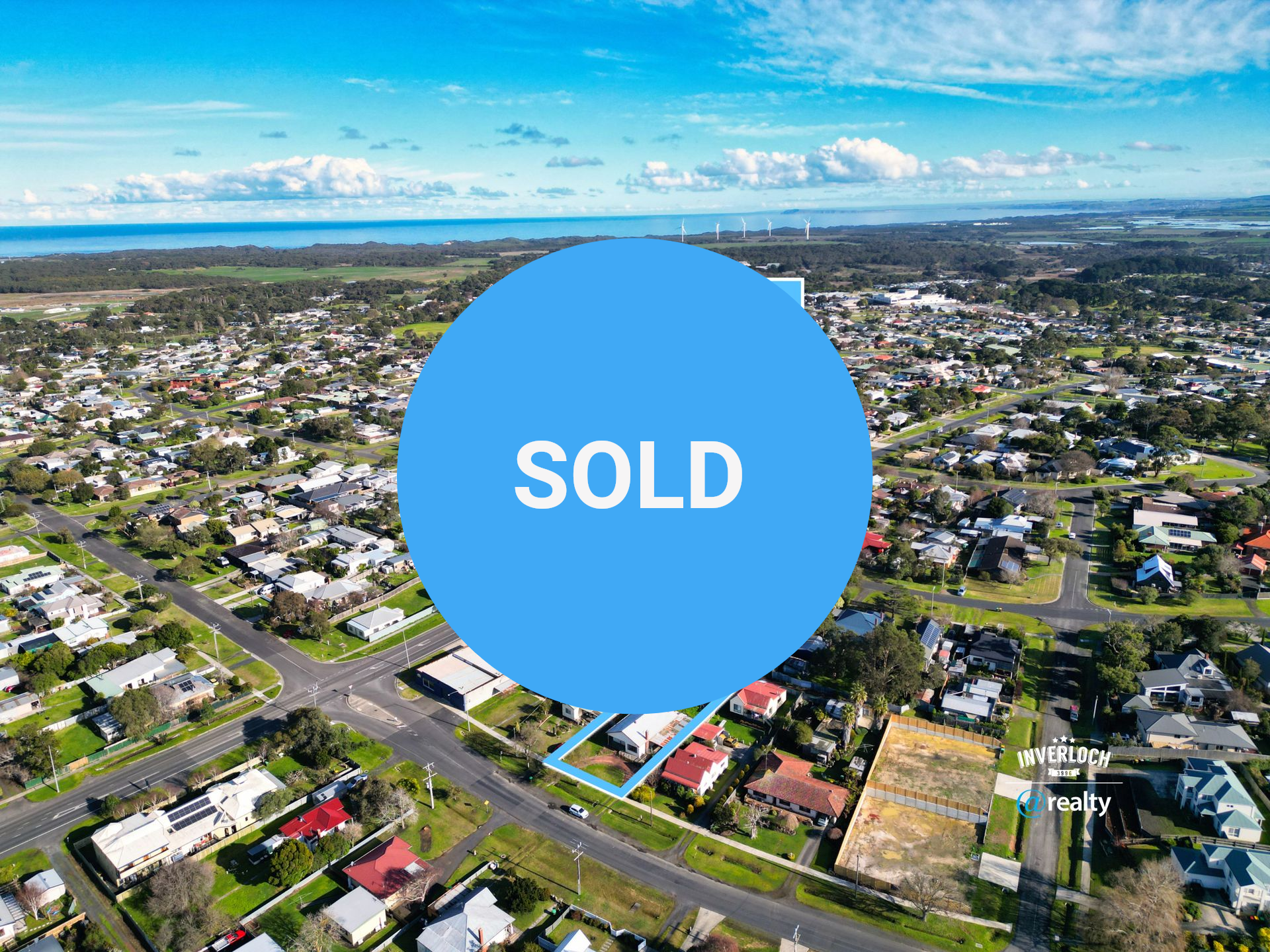 Aerial view of a residential area with a property marked at 26 Beach Rd, featuring houses, roads, and the sea.