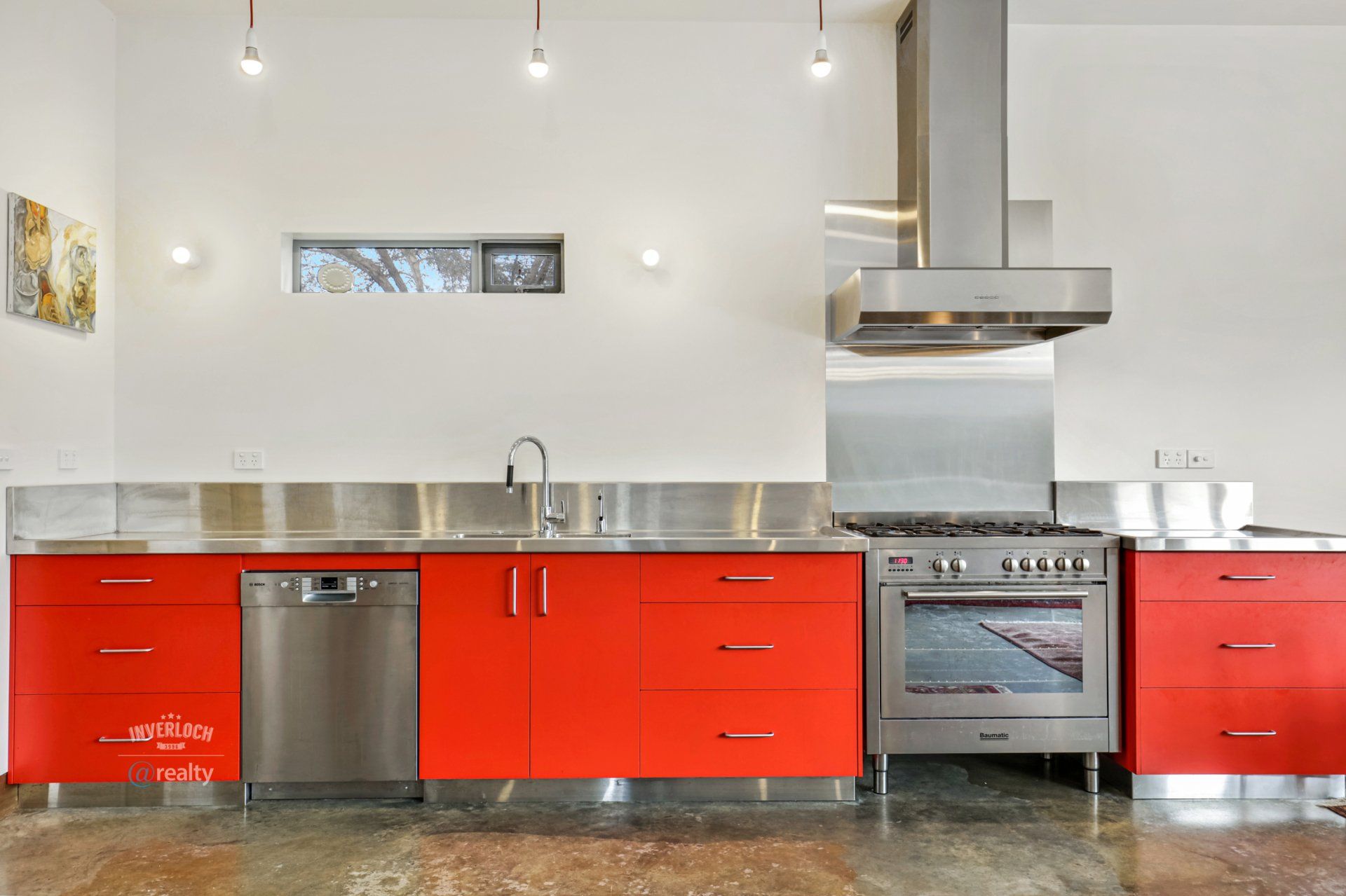 A kitchen with red cabinets and stainless steel appliances