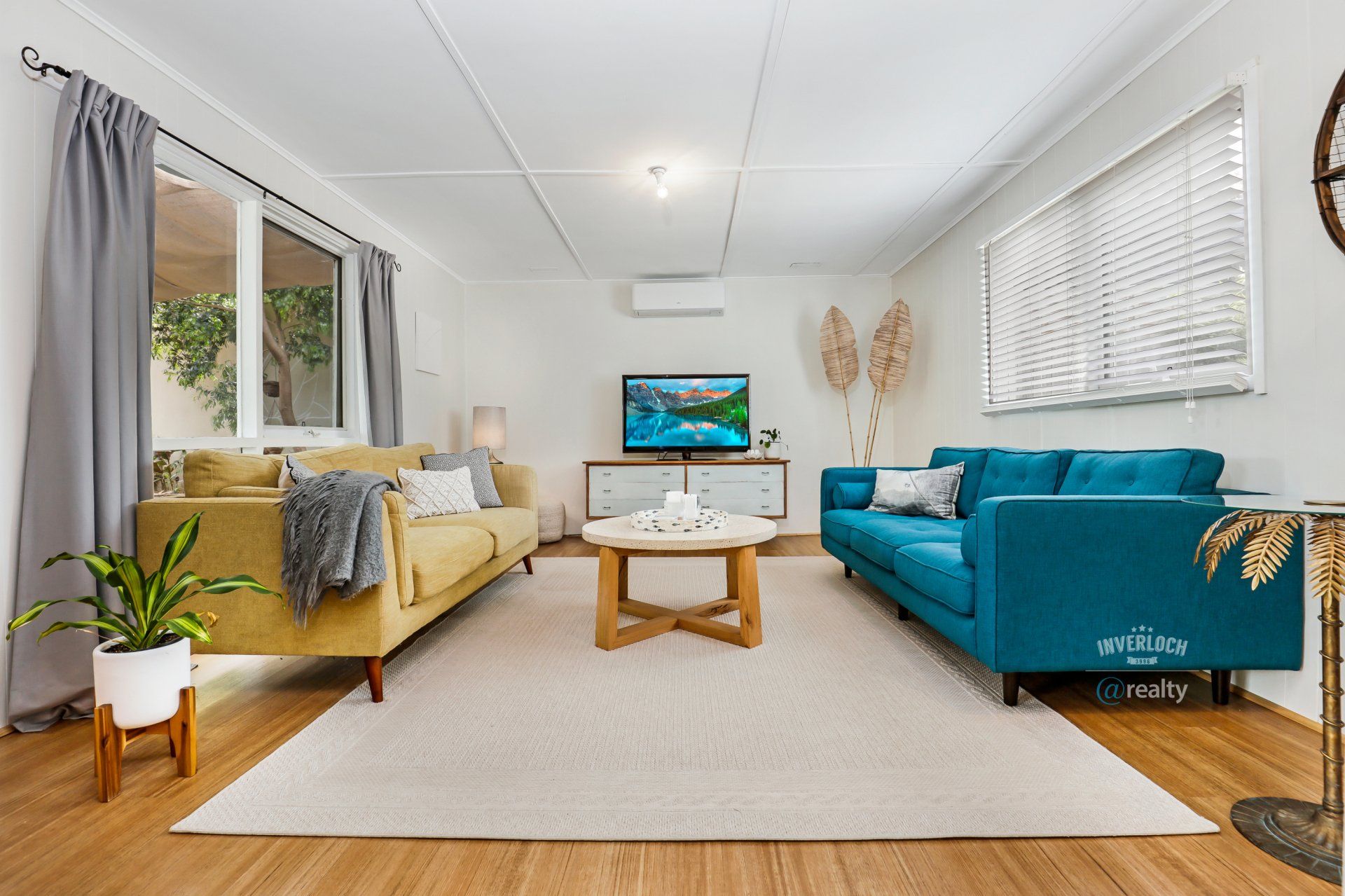 A living room with two couches , a coffee table , and a television.