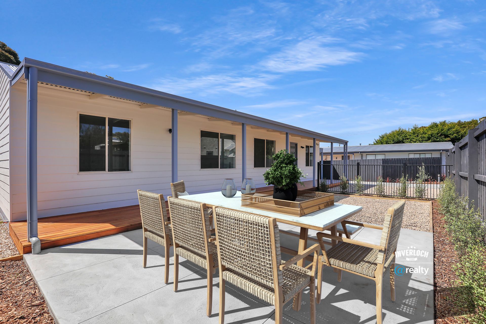 A patio with a table and chairs in front of a house.