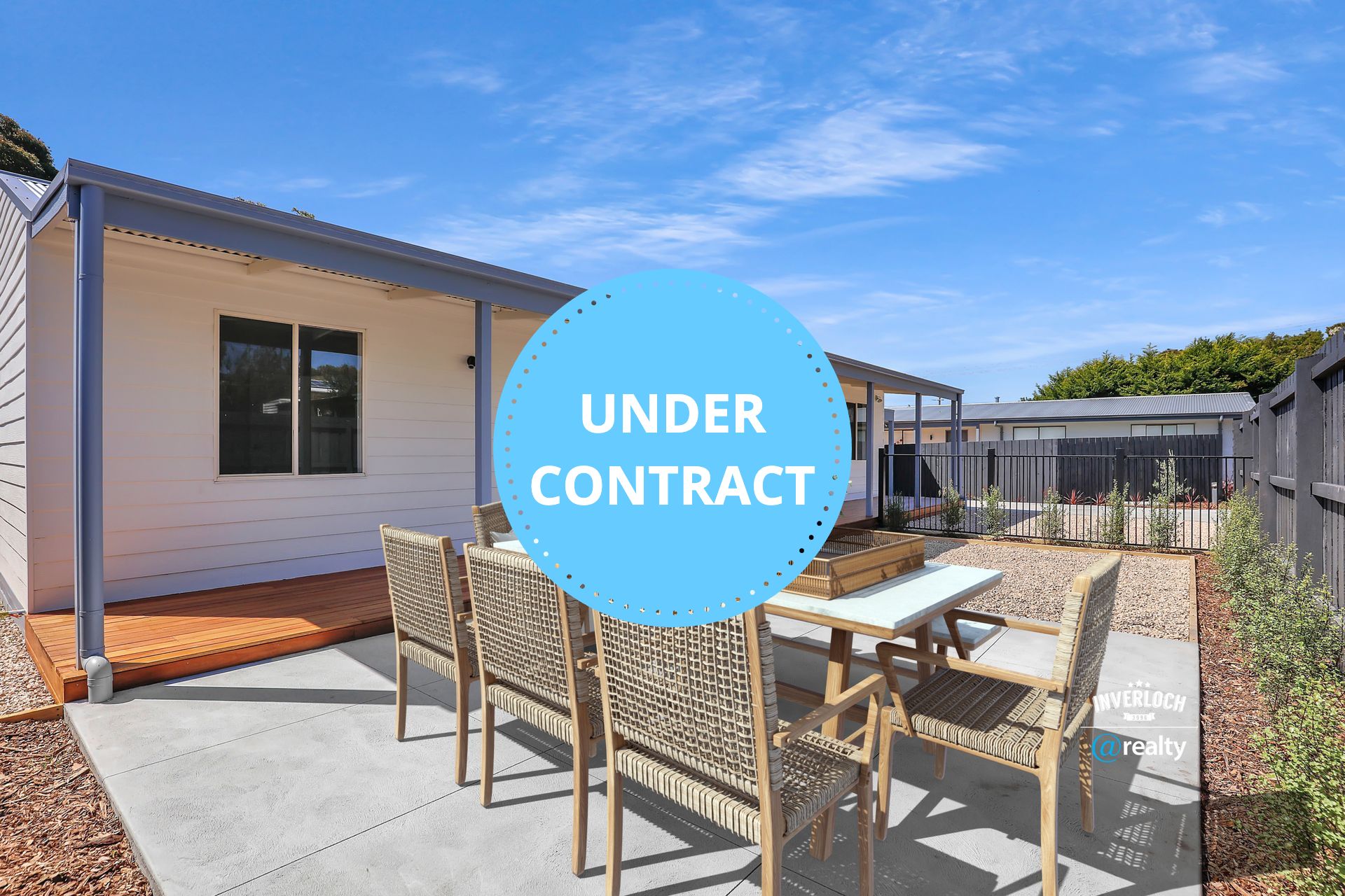 A patio with a table and chairs in front of a house.