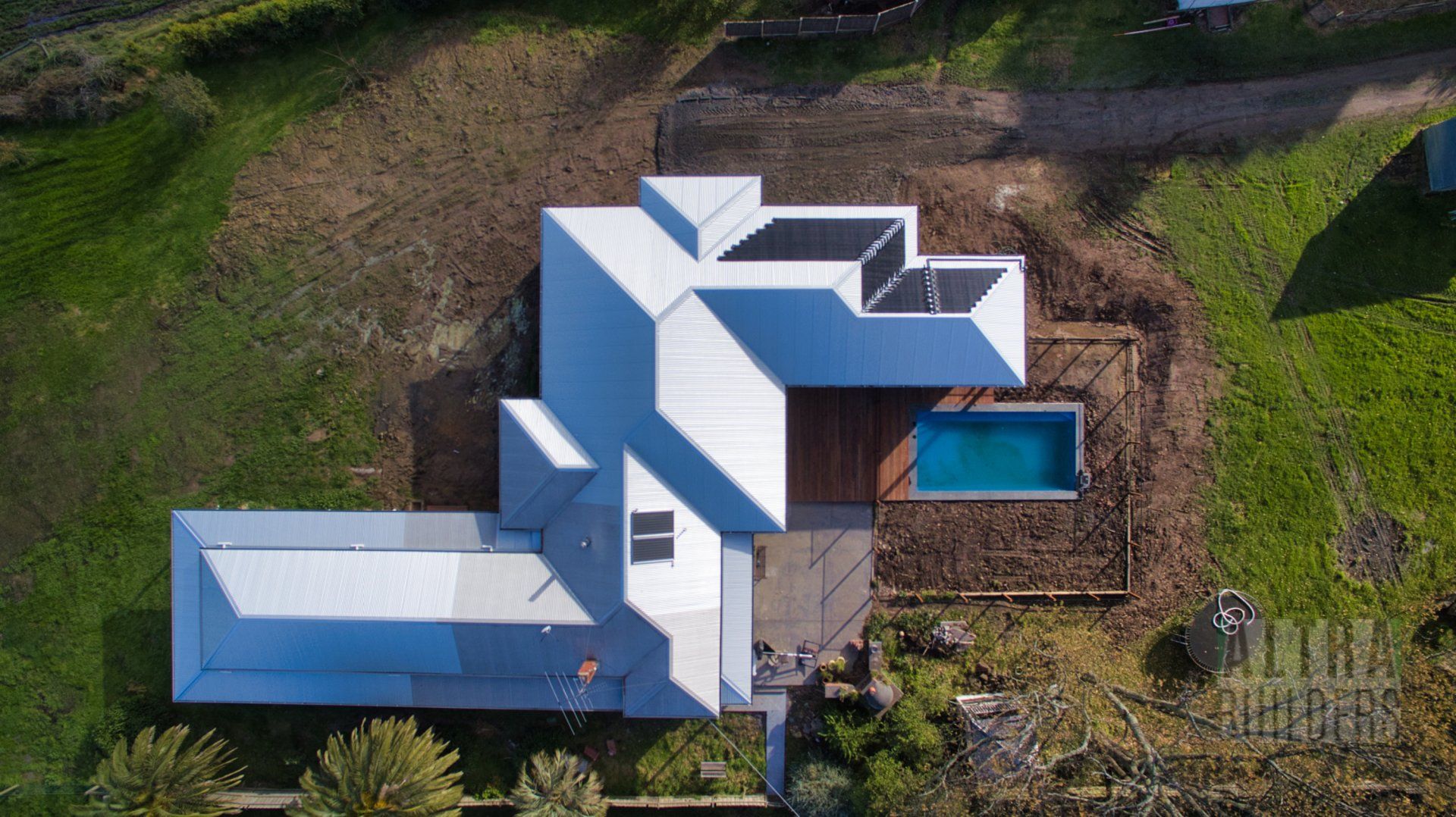 An aerial view of a house with a pool in the backyard.