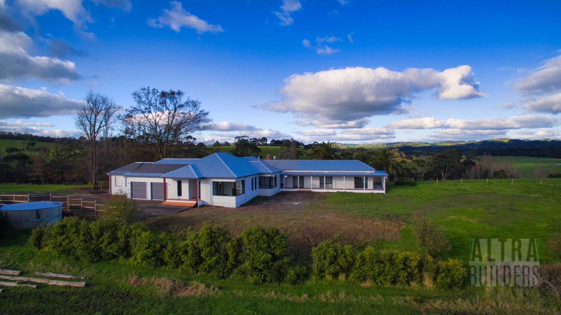 An aerial view of a house in the middle of a grassy field.