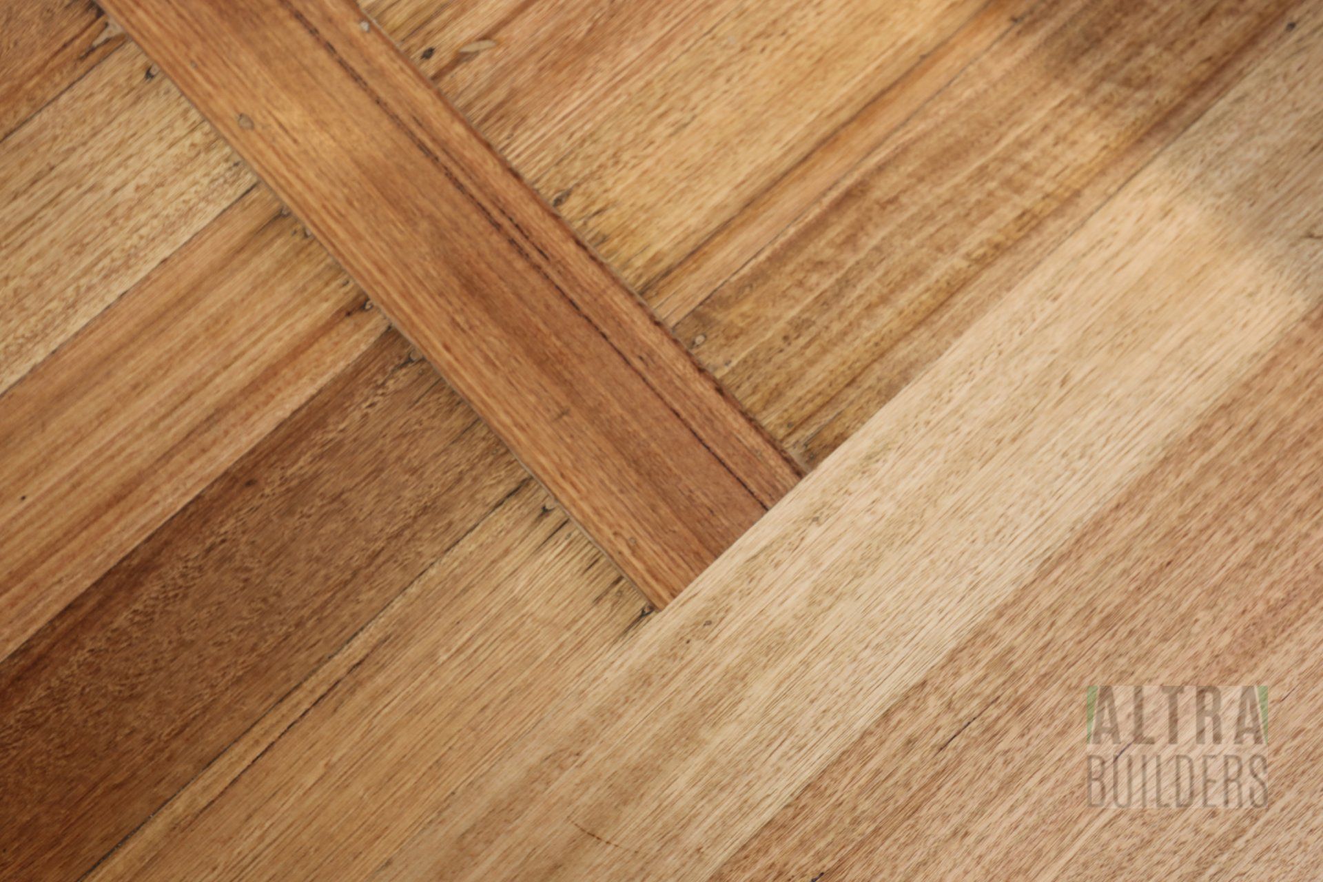 A close up of a wooden floor with a diagonal pattern.